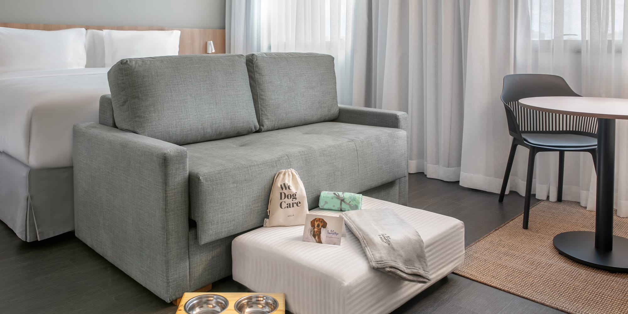 a couch with food bowls and a dog bed