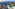Cala turquesa en Mallorca con playa, villas blancas y pinos.
