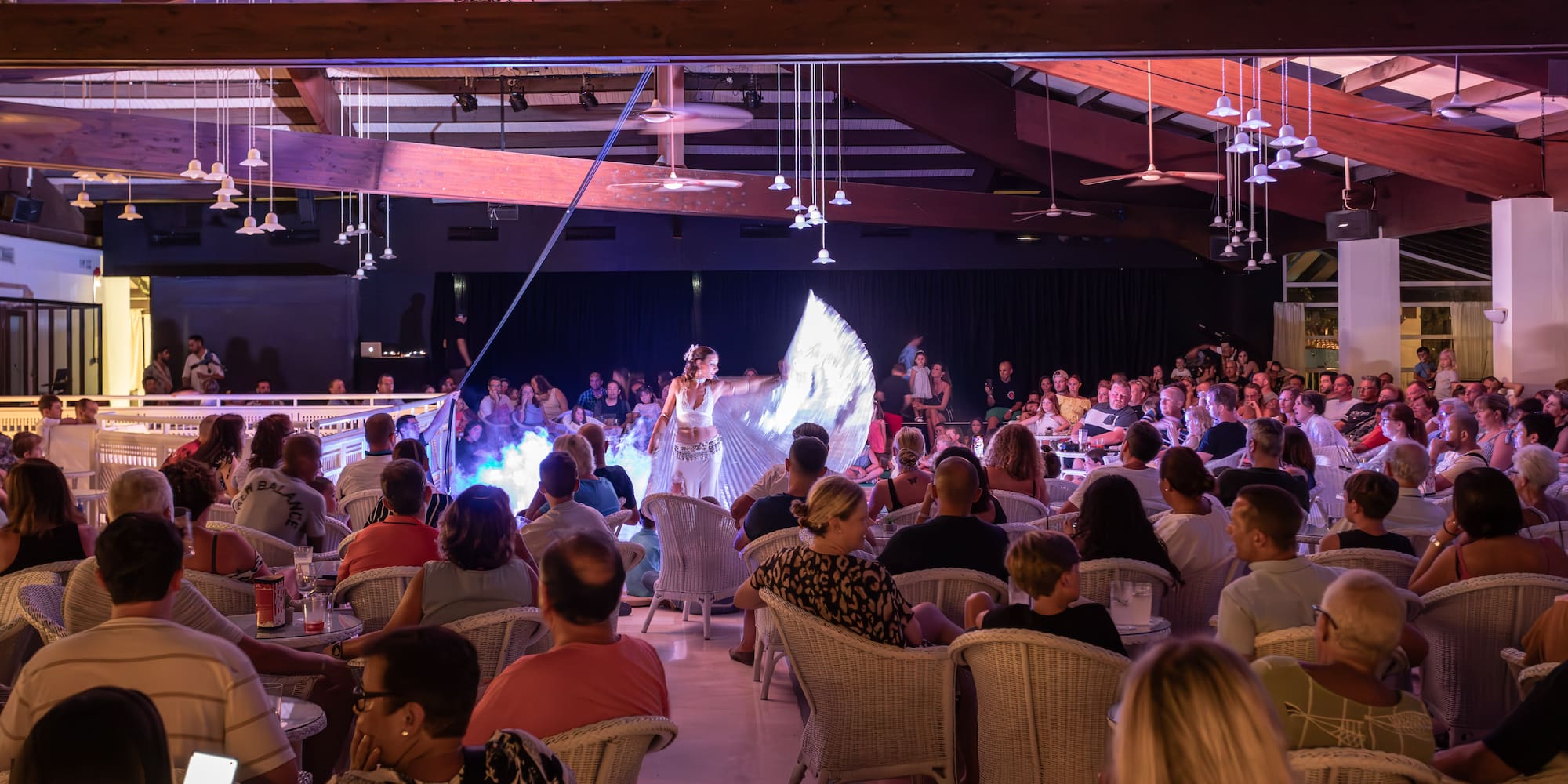 a woman performing on stage with a crowd of people