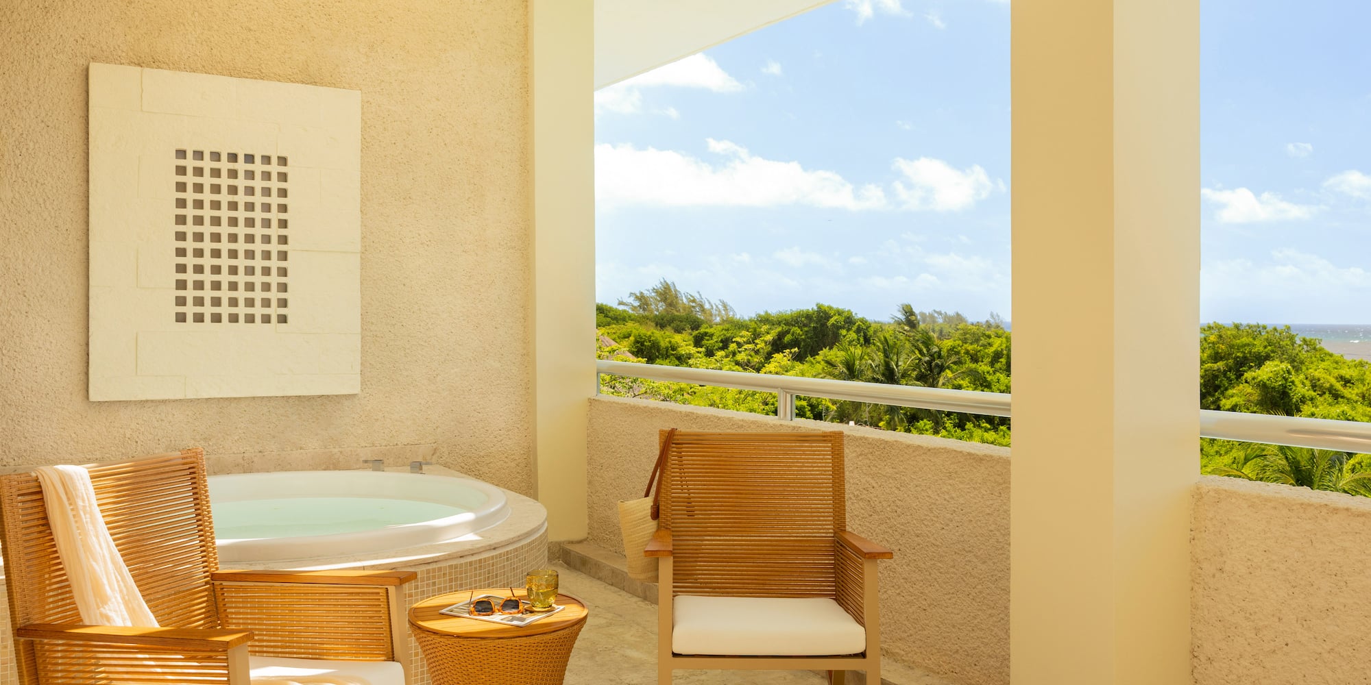 Tropical balcony with hot tub, lounge chairs, and ocean view.