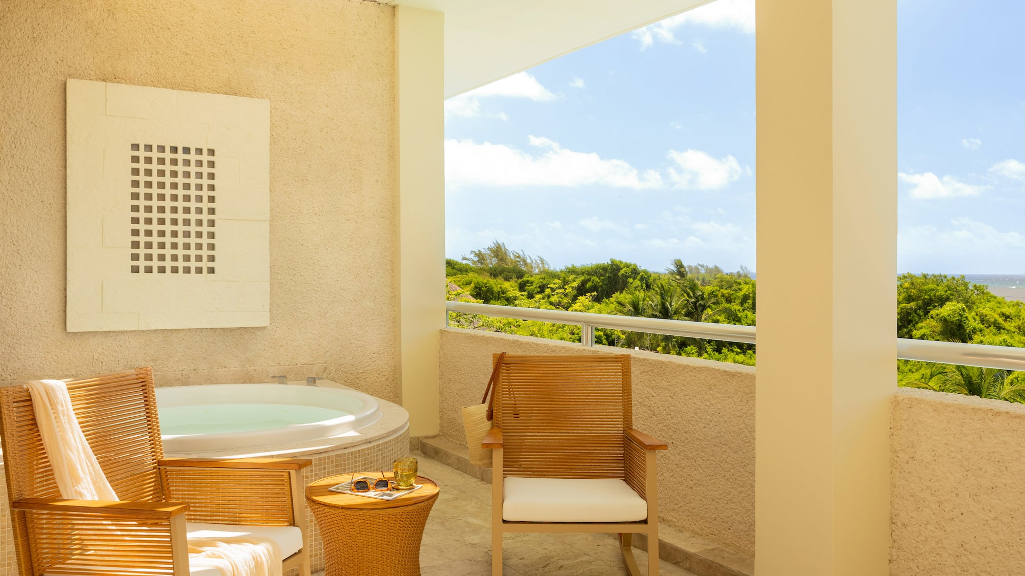 Tropical balcony with hot tub, lounge chairs, and ocean view.
