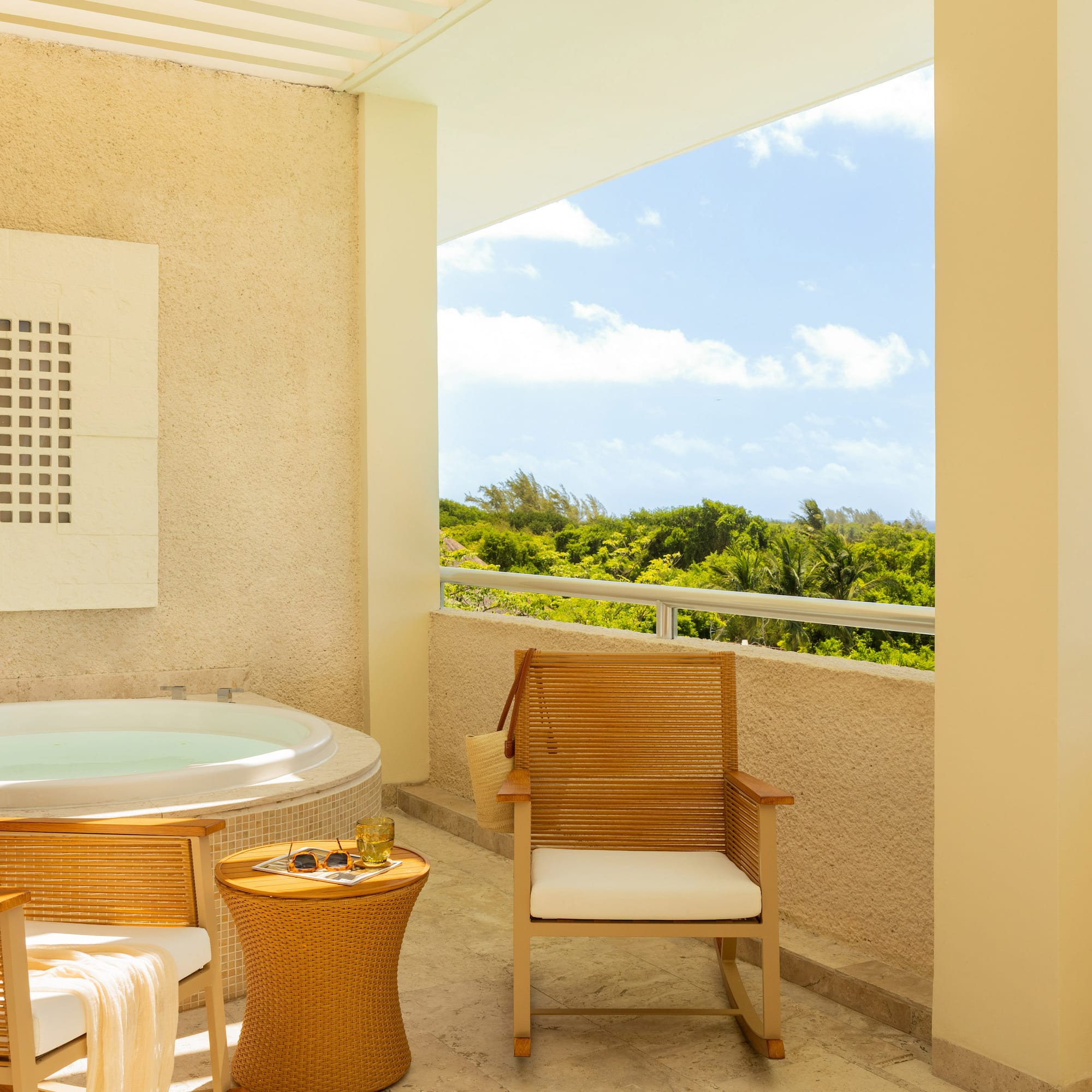 Tropical balcony with hot tub, lounge chairs, and ocean view.