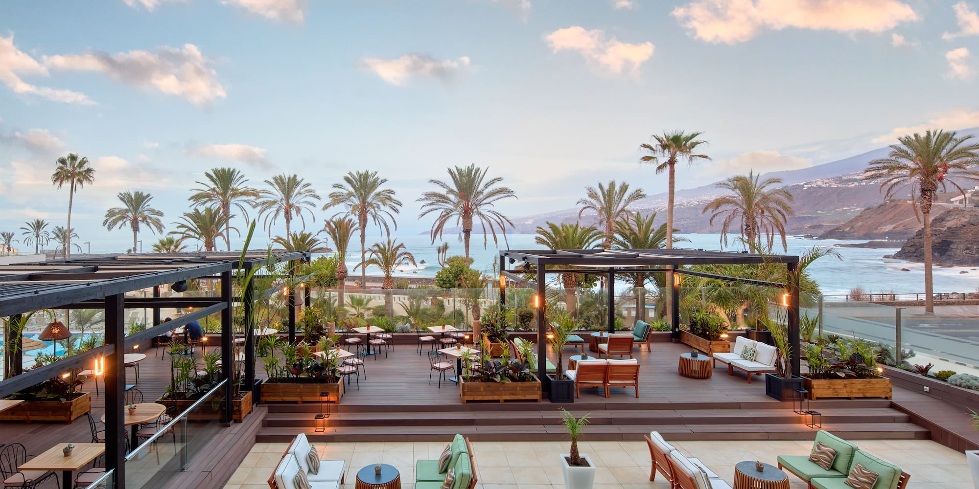 a deck with chairs and tables and palm trees