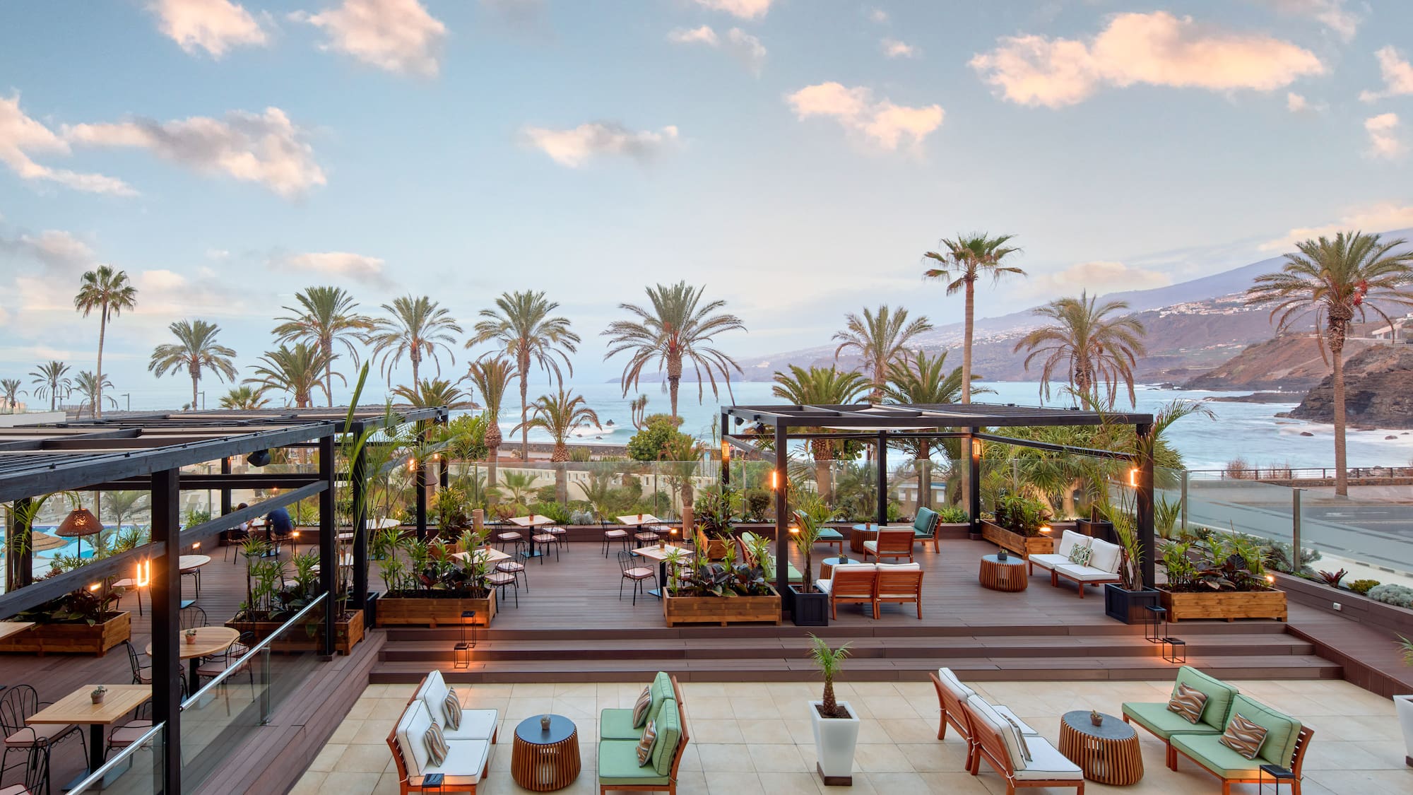 a deck with chairs and tables and palm trees