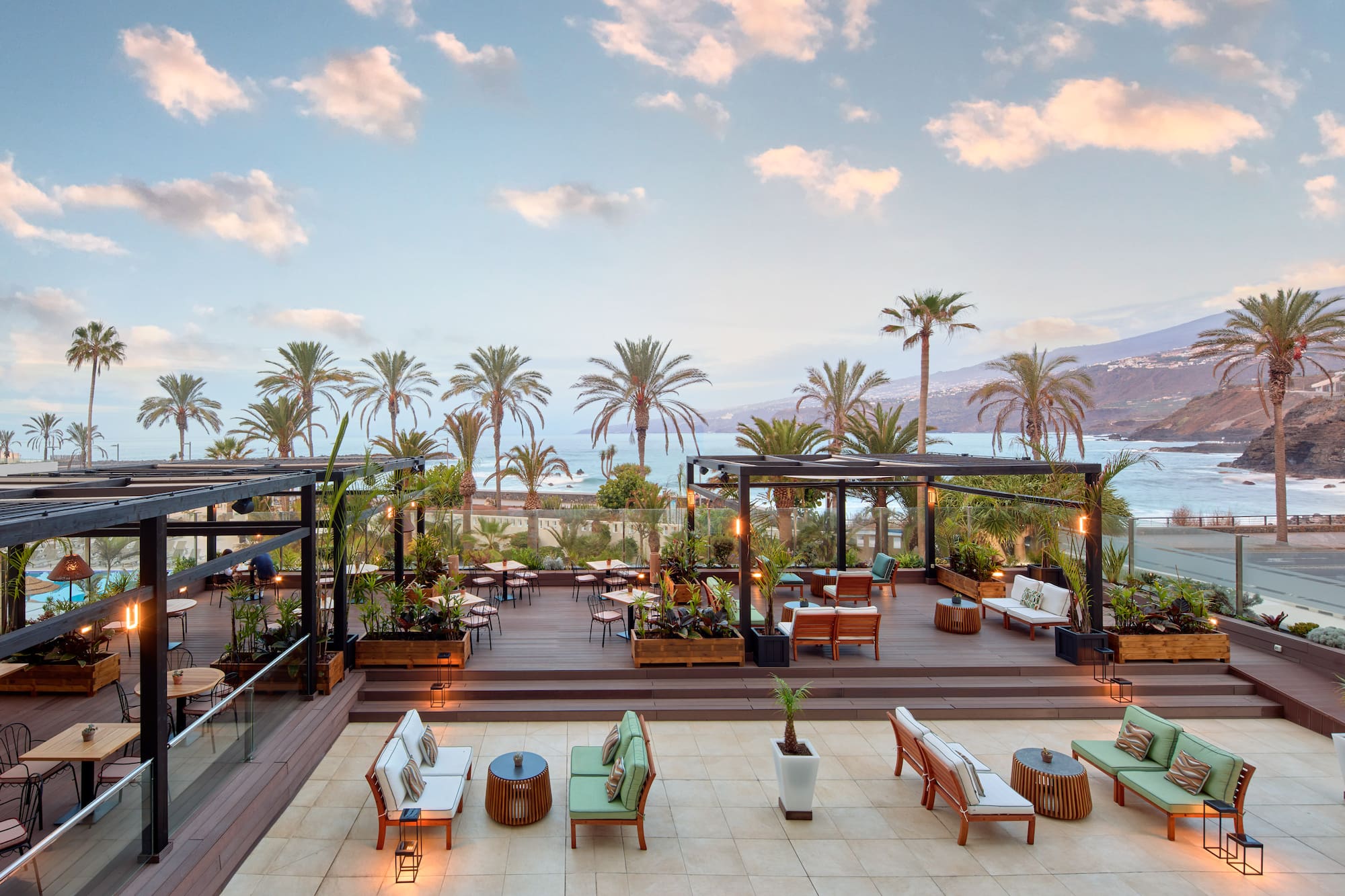 a deck with chairs and tables and palm trees
