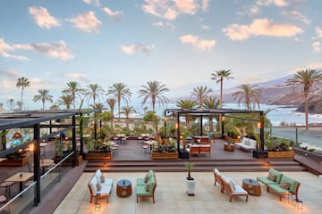a deck with chairs and tables and palm trees