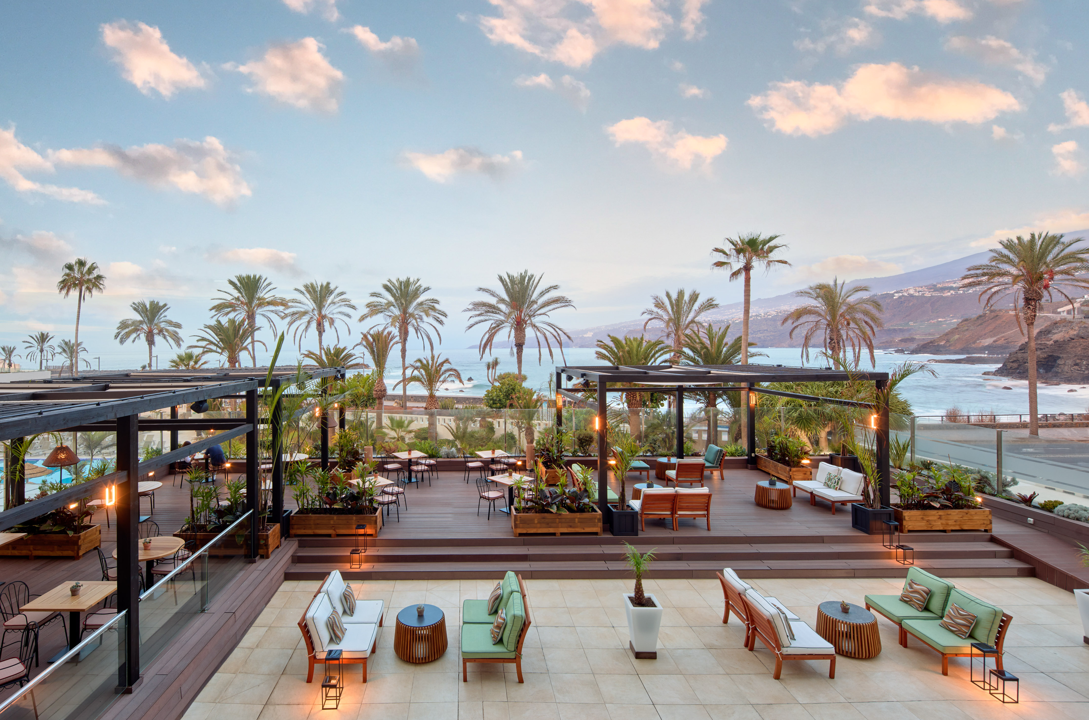 a deck with chairs and tables and palm trees