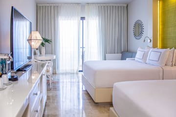 a bedroom with two beds and a television