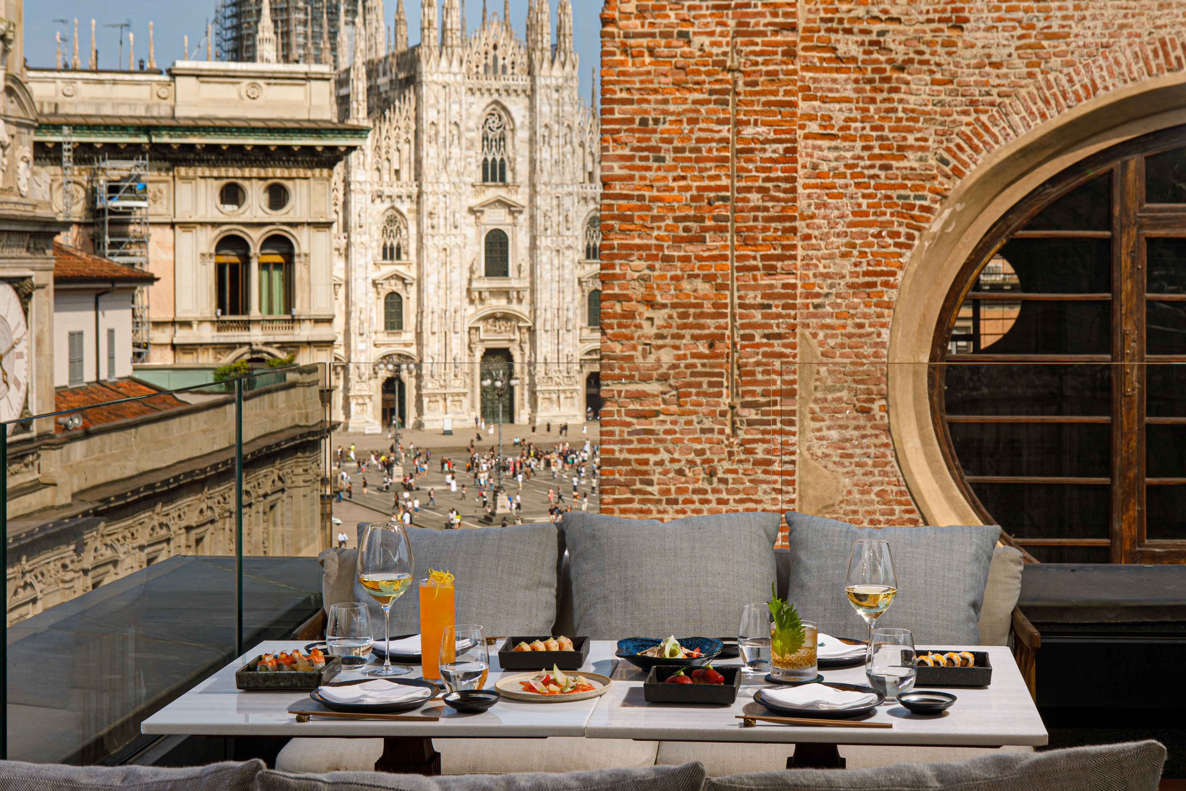 Sushi and cocktails on a Milan rooftop terrace with Duomo view.