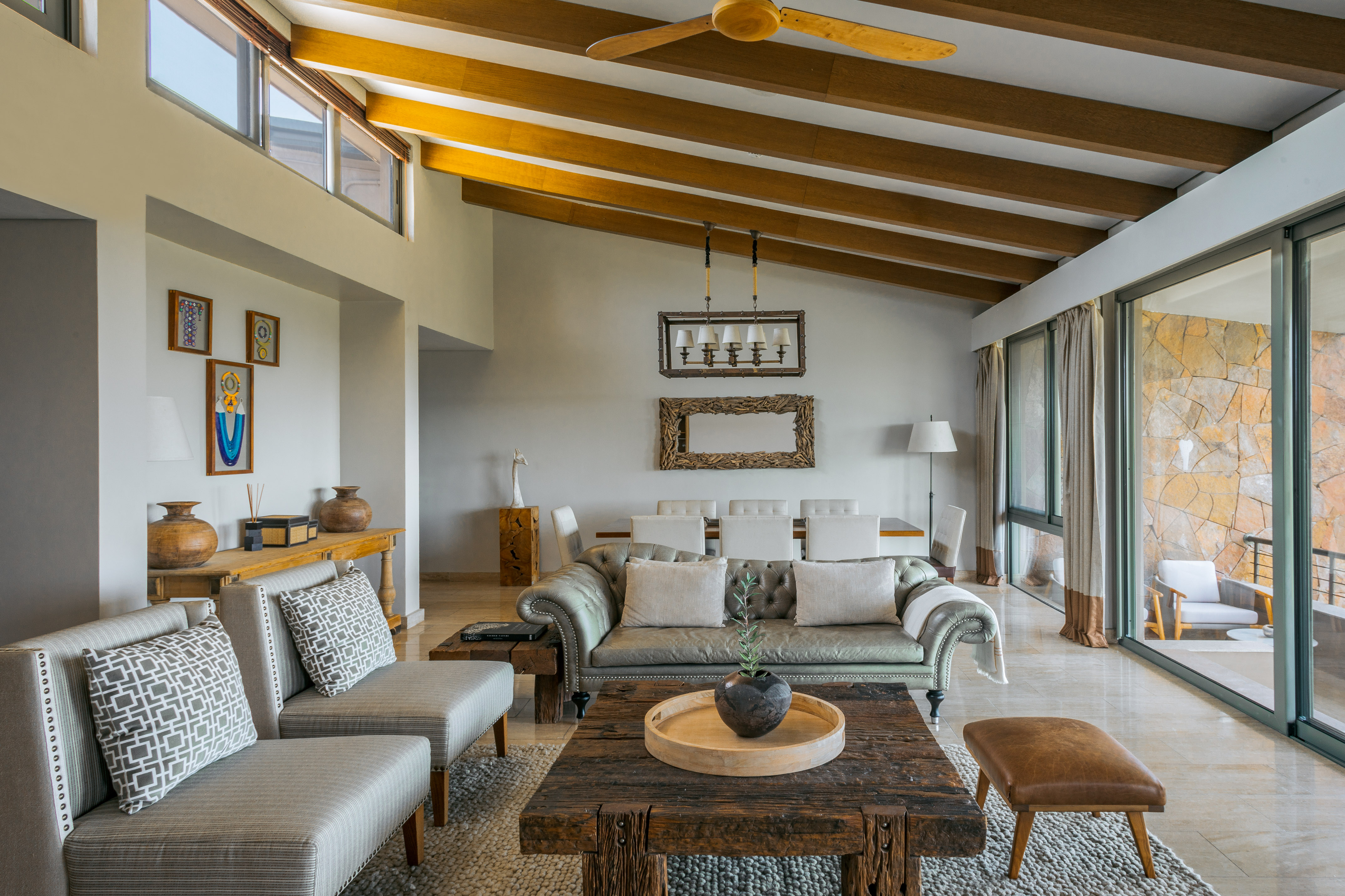 Modern open living-dining room, vaulted wood ceiling, rustic coffee table.