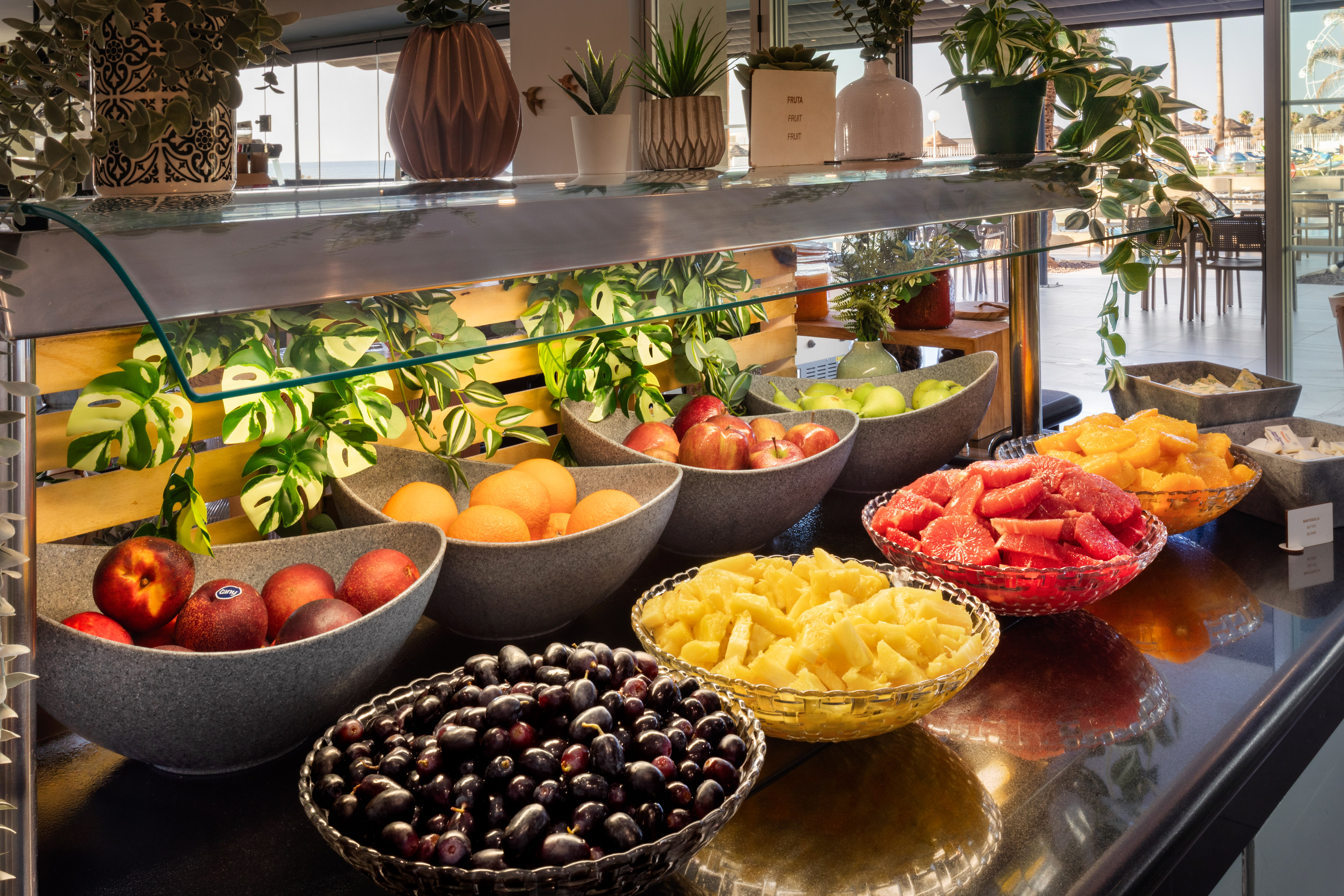 Fresh fruit buffet at resort: grapes, oranges, apples, pineapple, watermelon.
