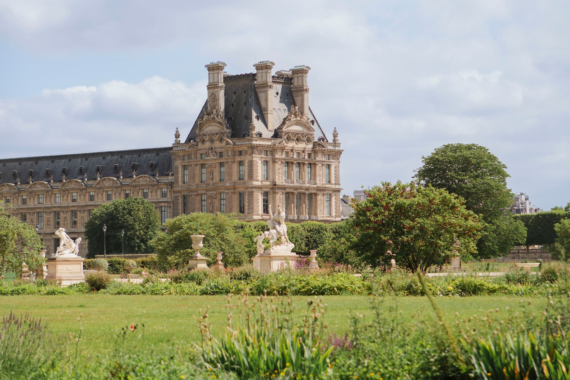 a large building with a lawn and trees