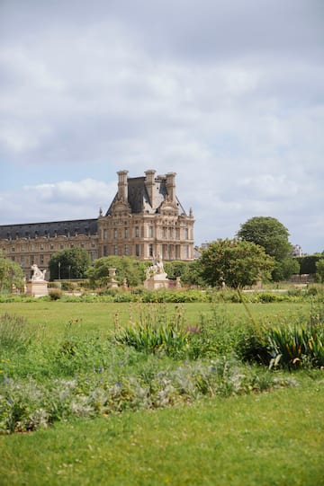 a large building with a lawn and trees