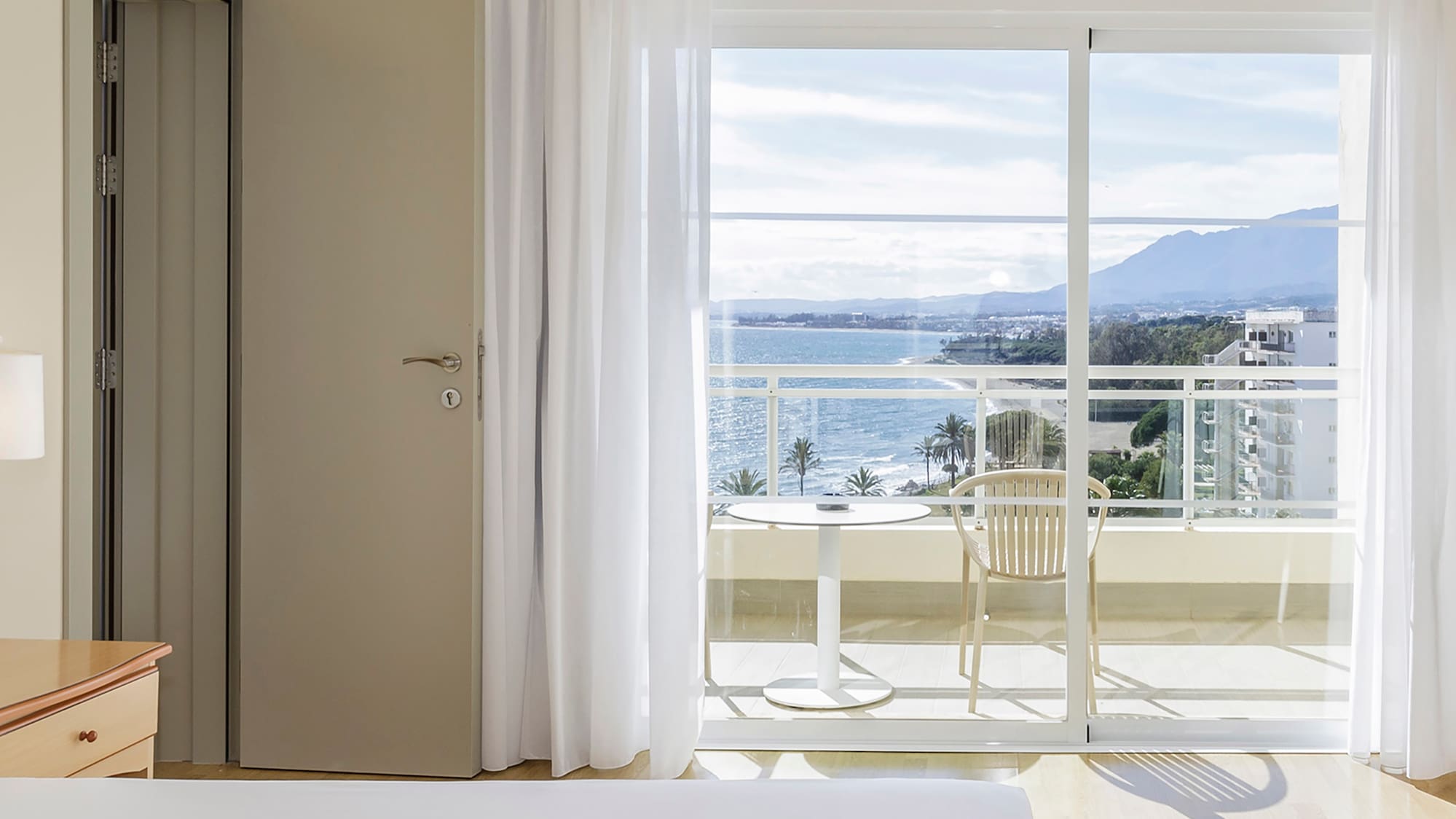 a bedroom with a view of the ocean and a balcony