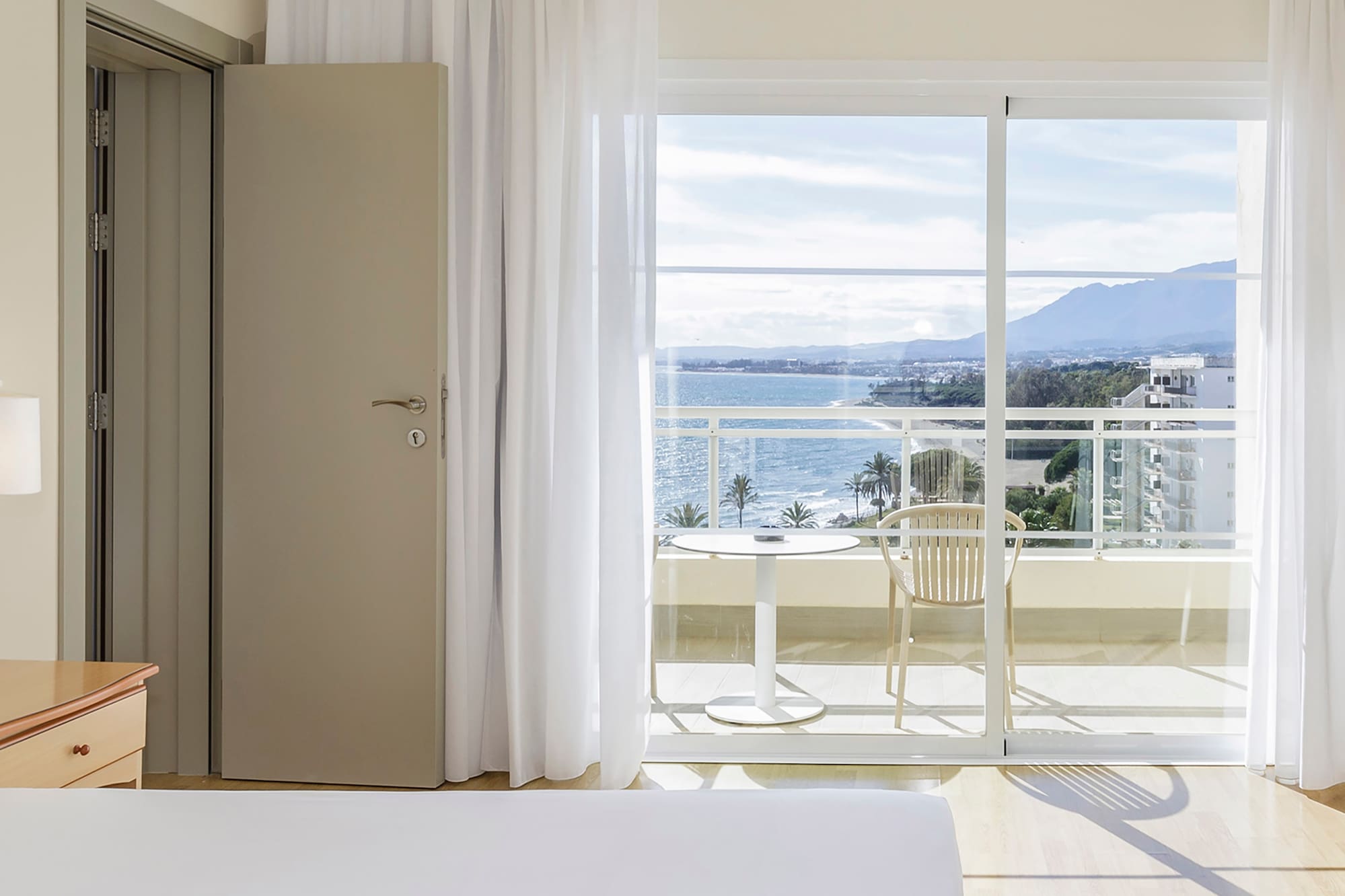 a bedroom with a view of the ocean and a balcony