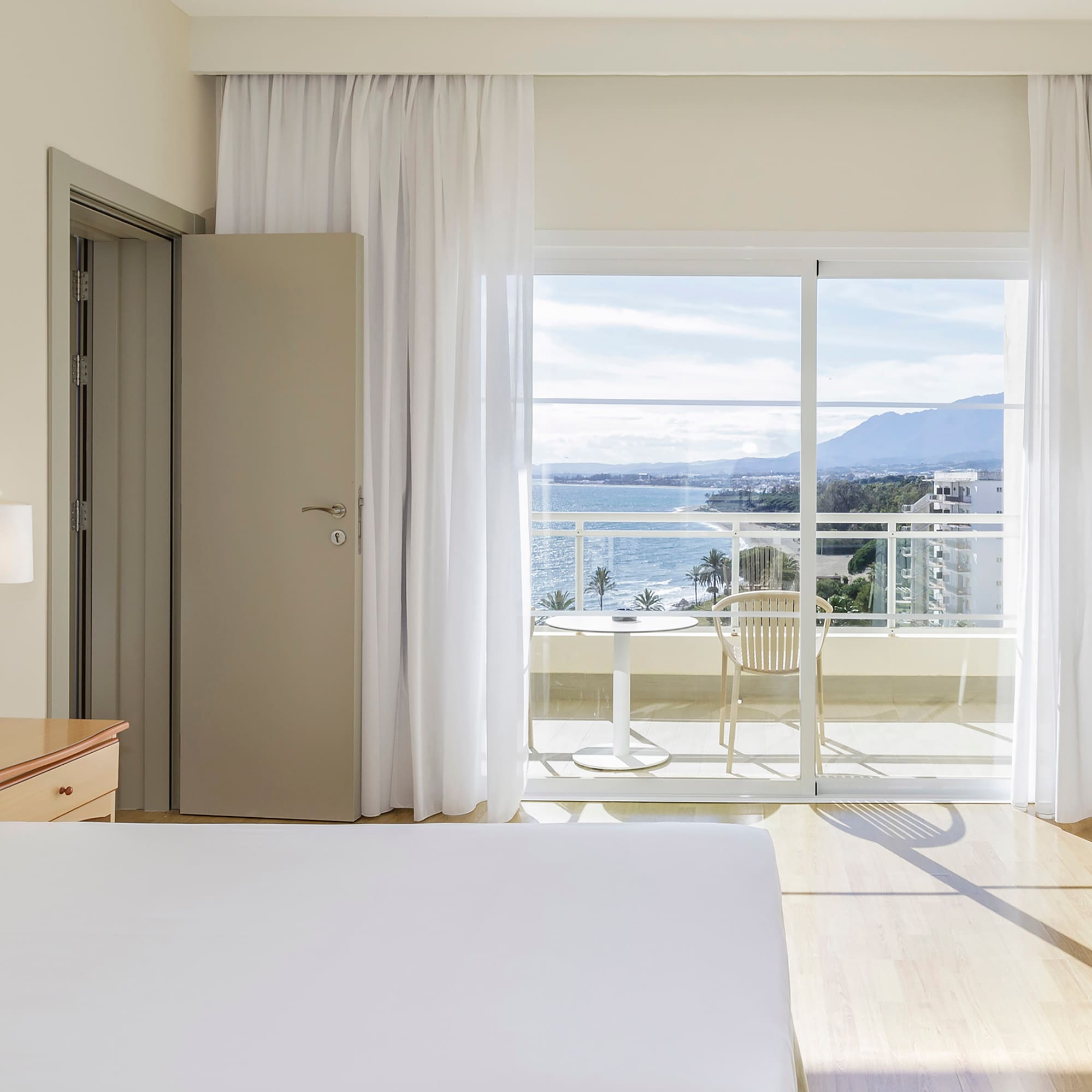 a bedroom with a view of the ocean and a balcony