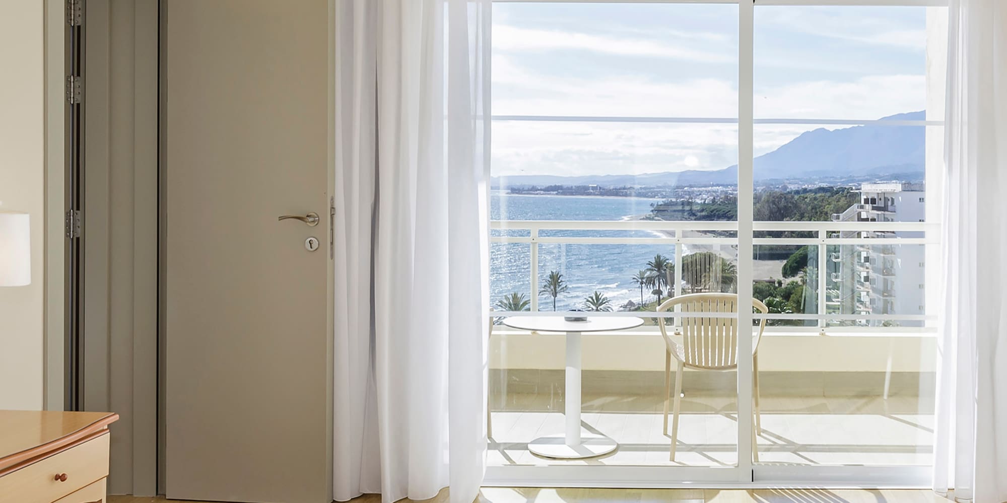 a bedroom with a view of the ocean and a balcony