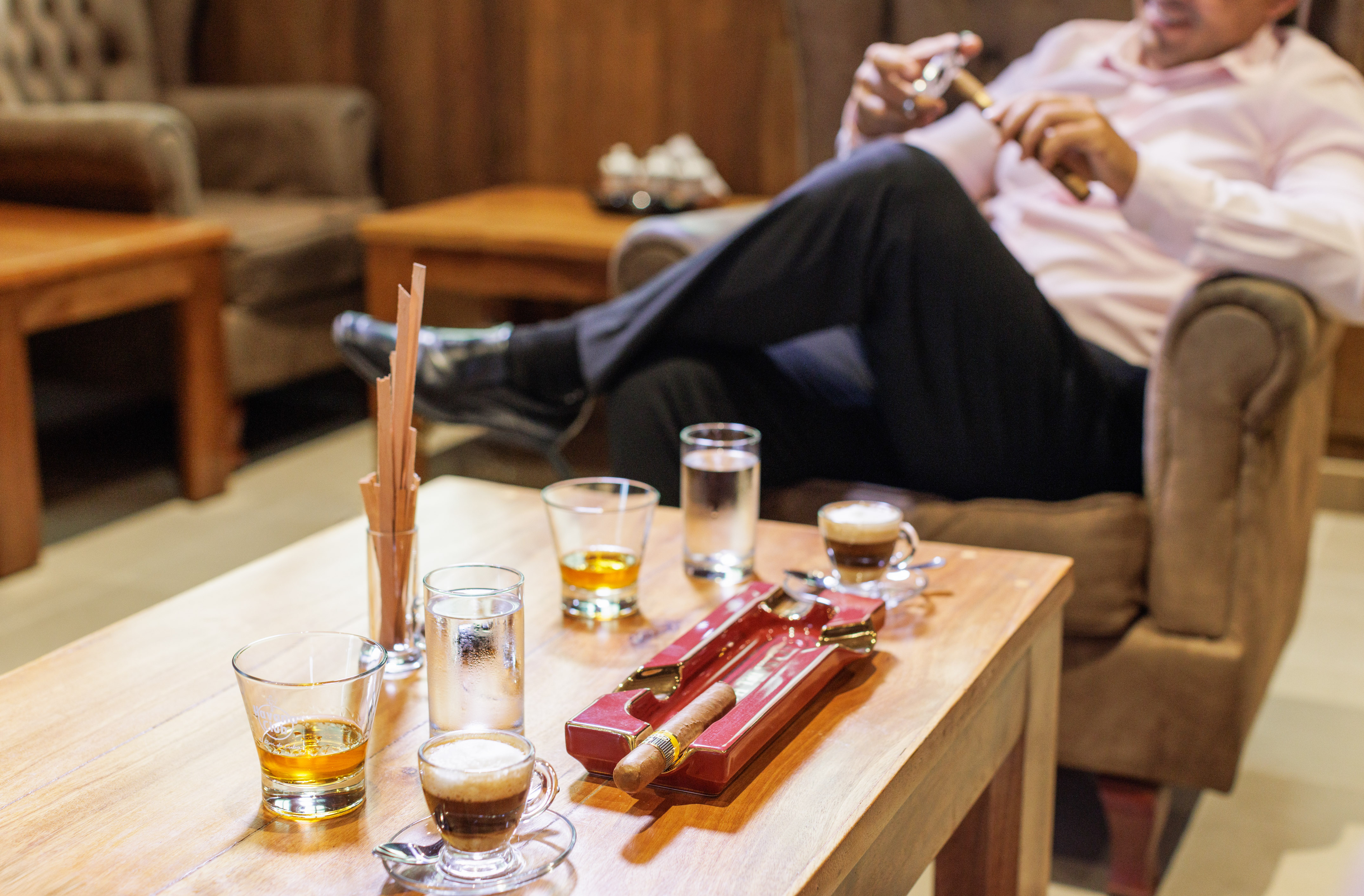 a man sitting on a couch smoking a cigar