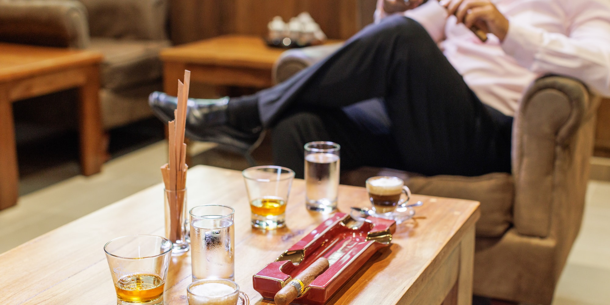 a man sitting on a couch smoking a cigar