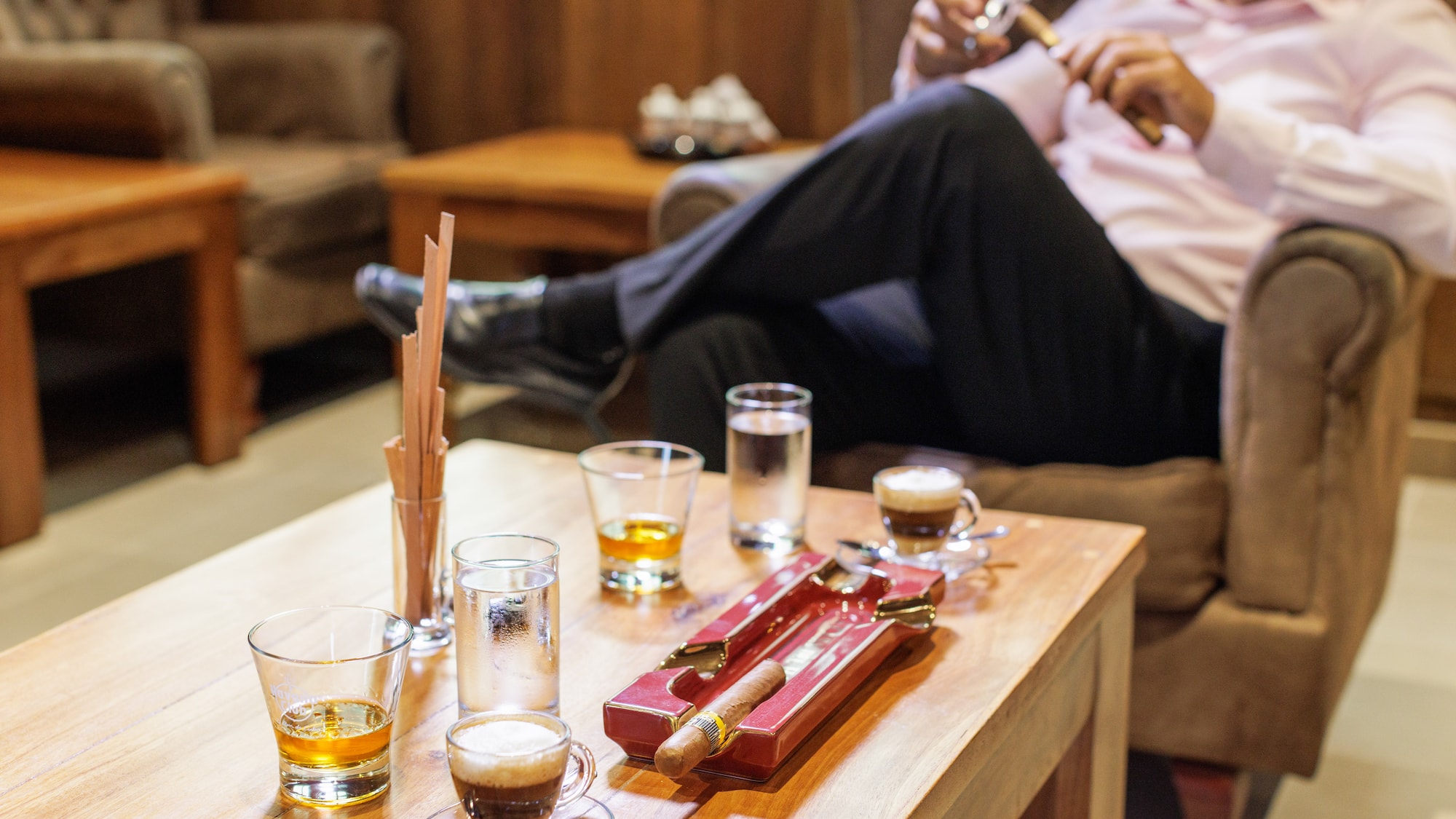 a man sitting on a couch smoking a cigar