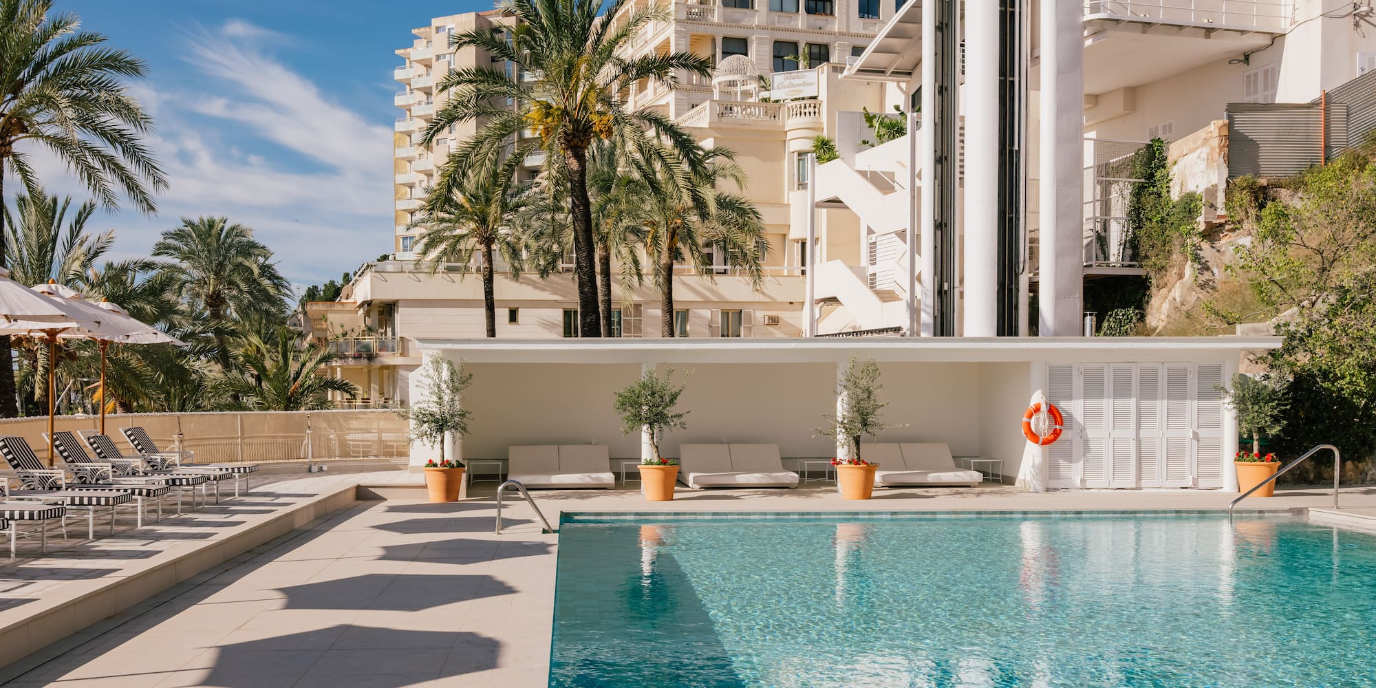 a pool with palm trees and a building in the background