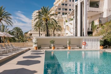 a pool with palm trees and a building in the background