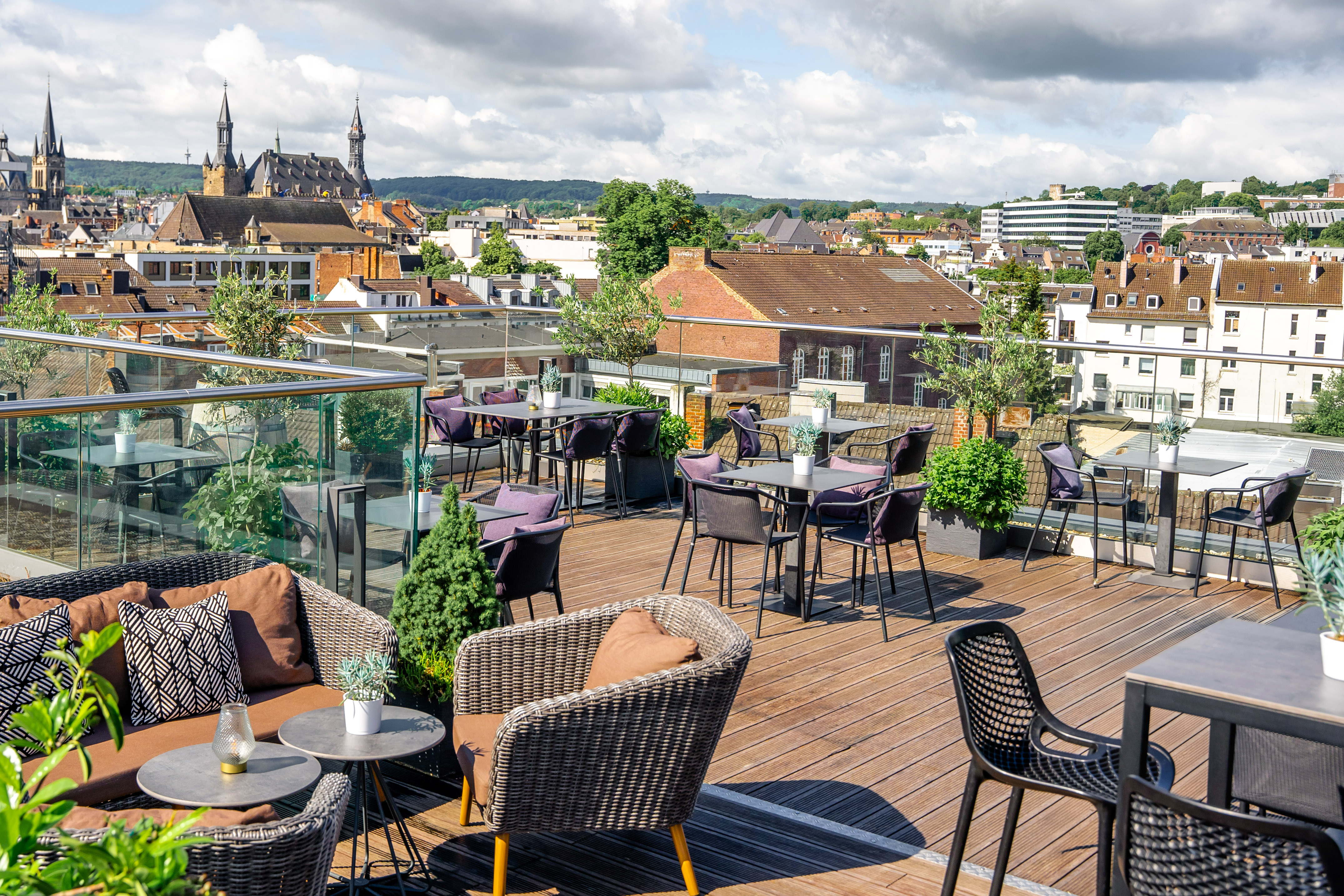 Rooftop terrace with modern outdoor seating and panoramic historic city view.