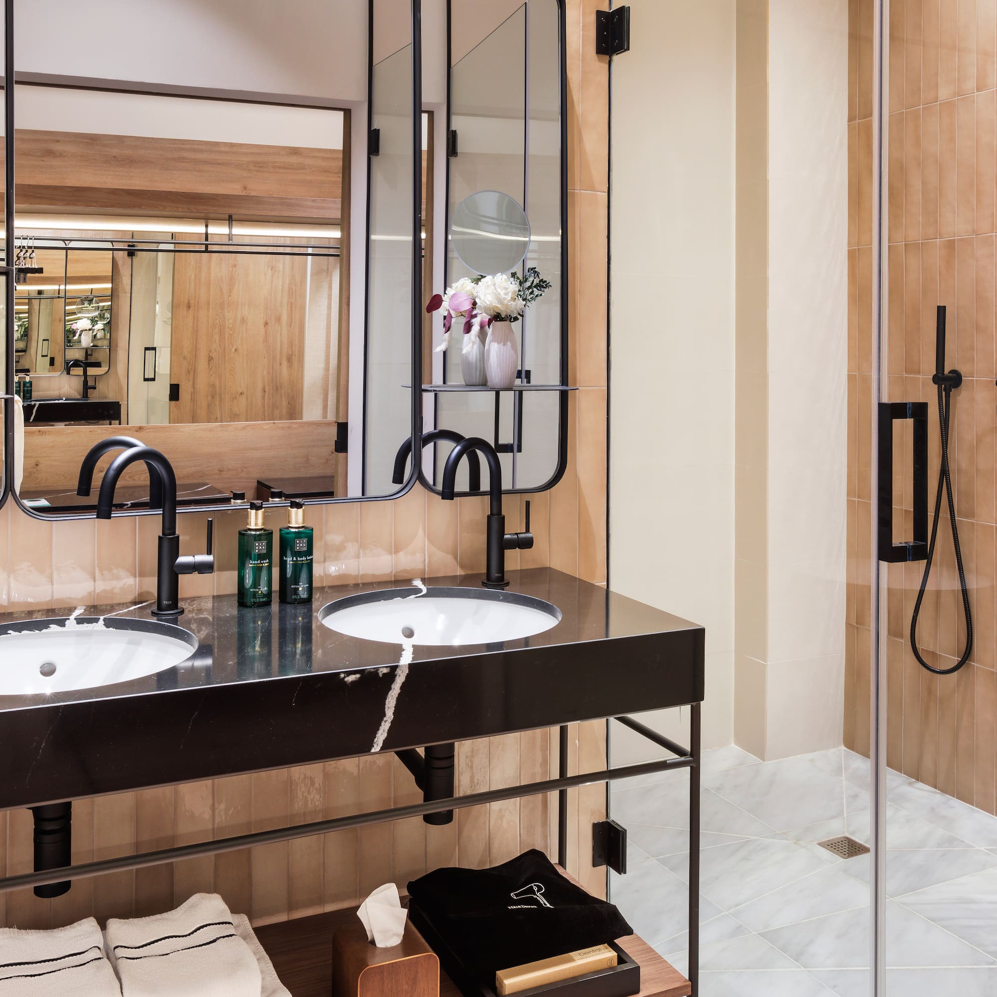 a bathroom with a shower and two sinks