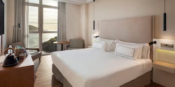 a room with a bed and a table and chairs