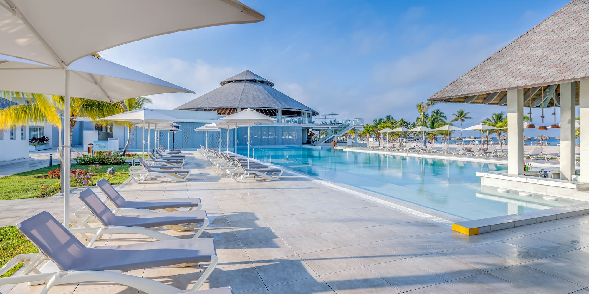 a pool with umbrellas and lounge chairs