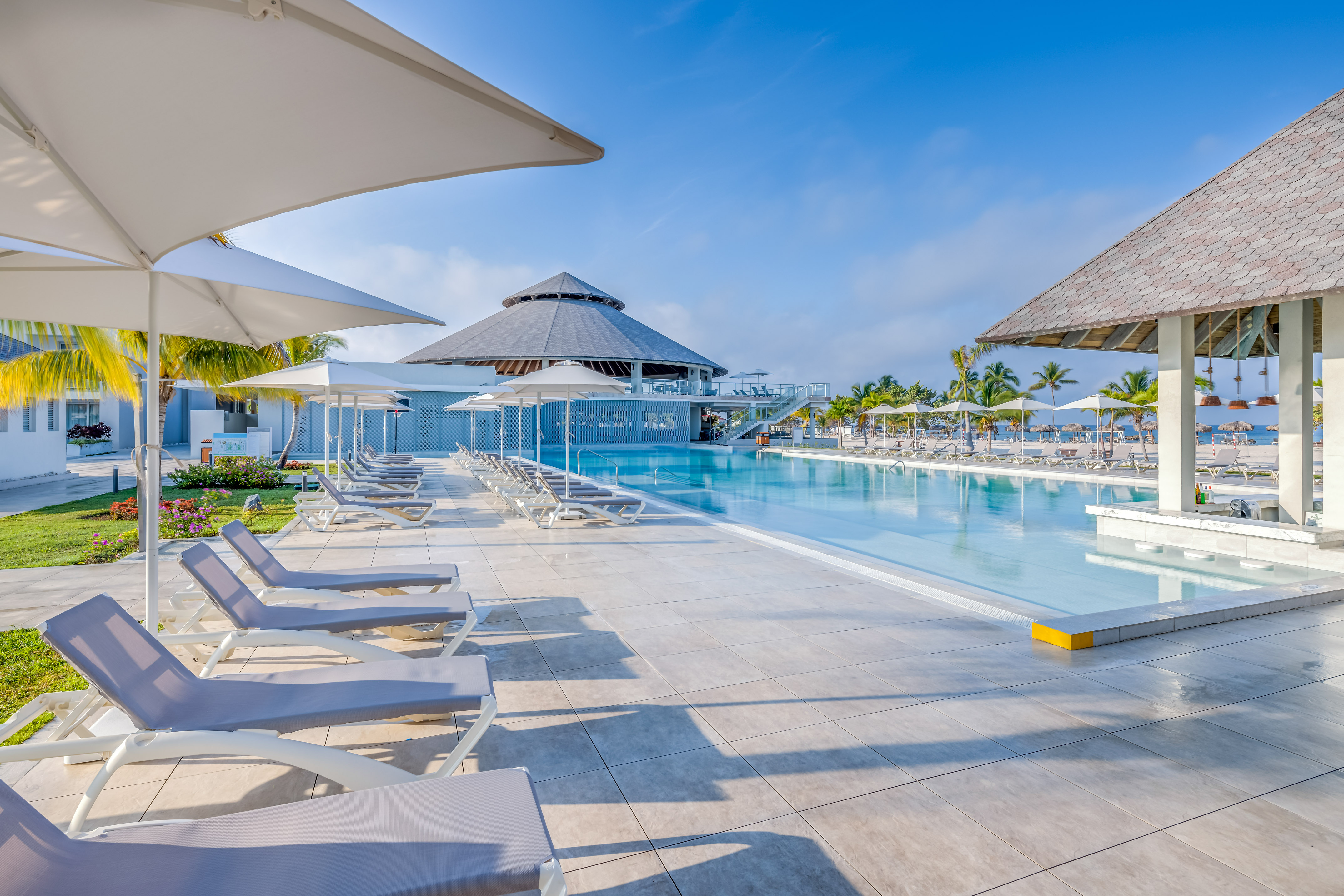 a pool with umbrellas and lounge chairs