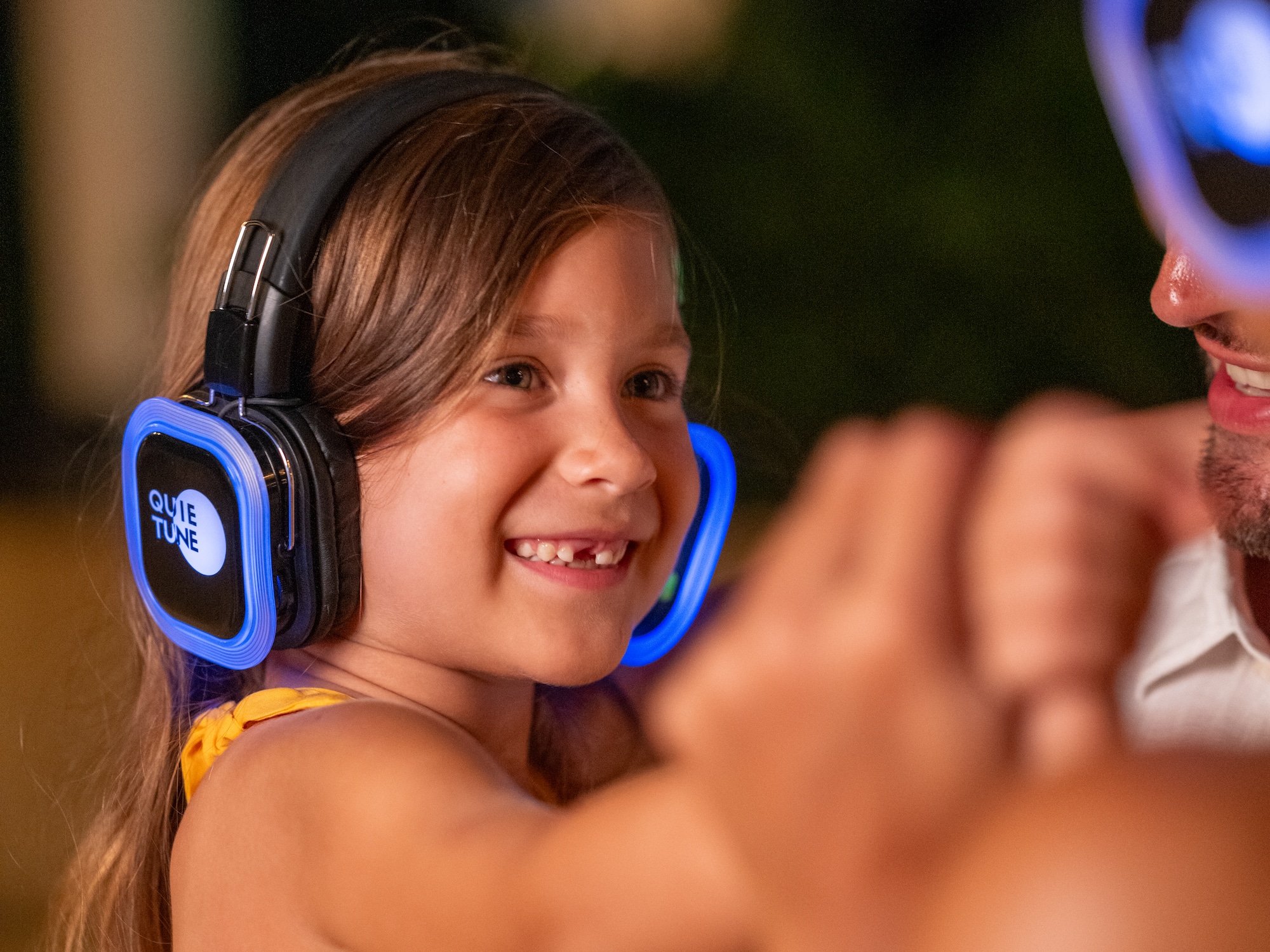a girl wearing headphones and smiling at a man