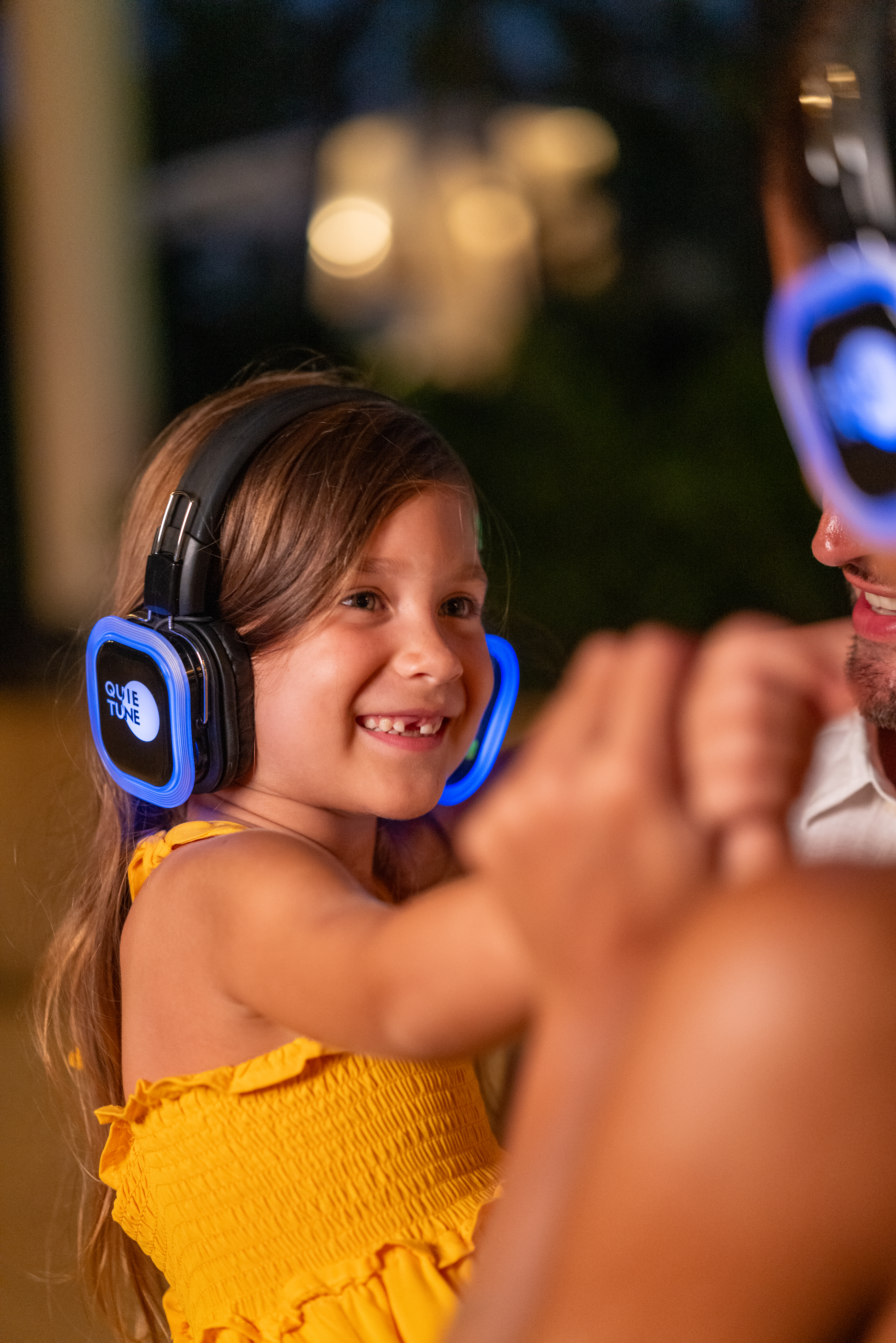 a girl wearing headphones and smiling at a man