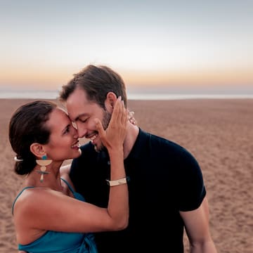 a man and woman hugging on a beach