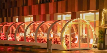 a glass structure with lights outside of a building