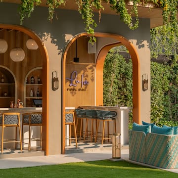 a bar with chairs and a bench in front of a patio