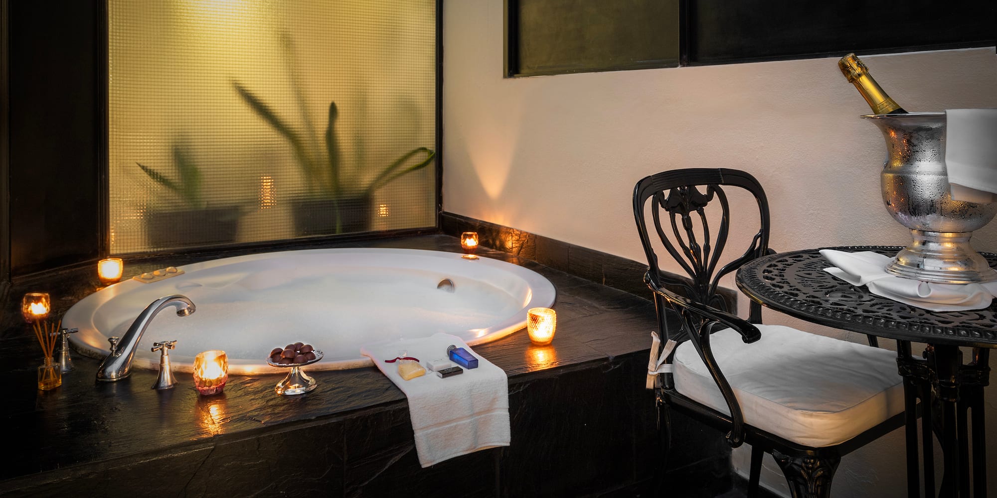 a hot tub with candles and a chair