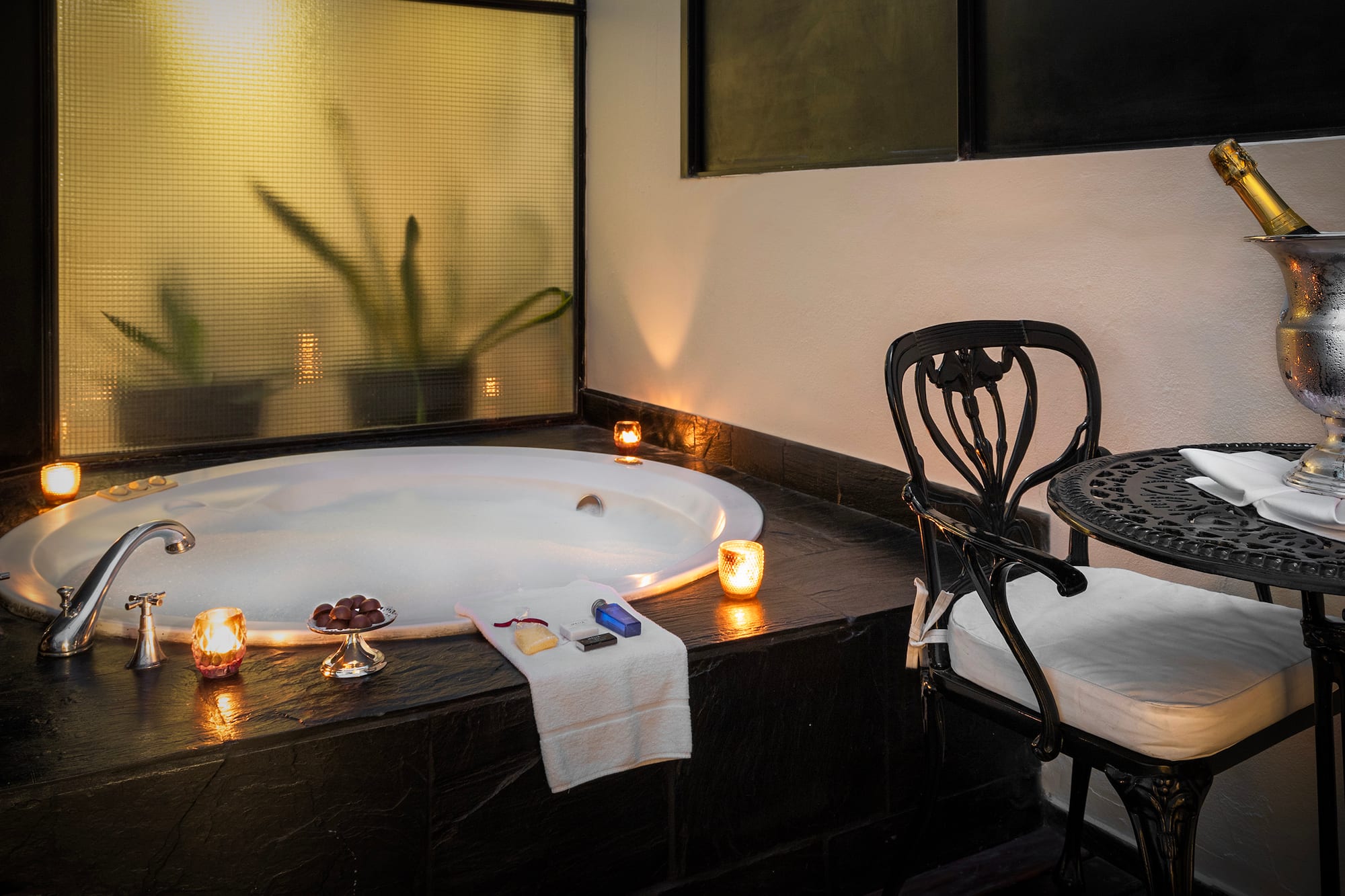 a hot tub with candles and a chair
