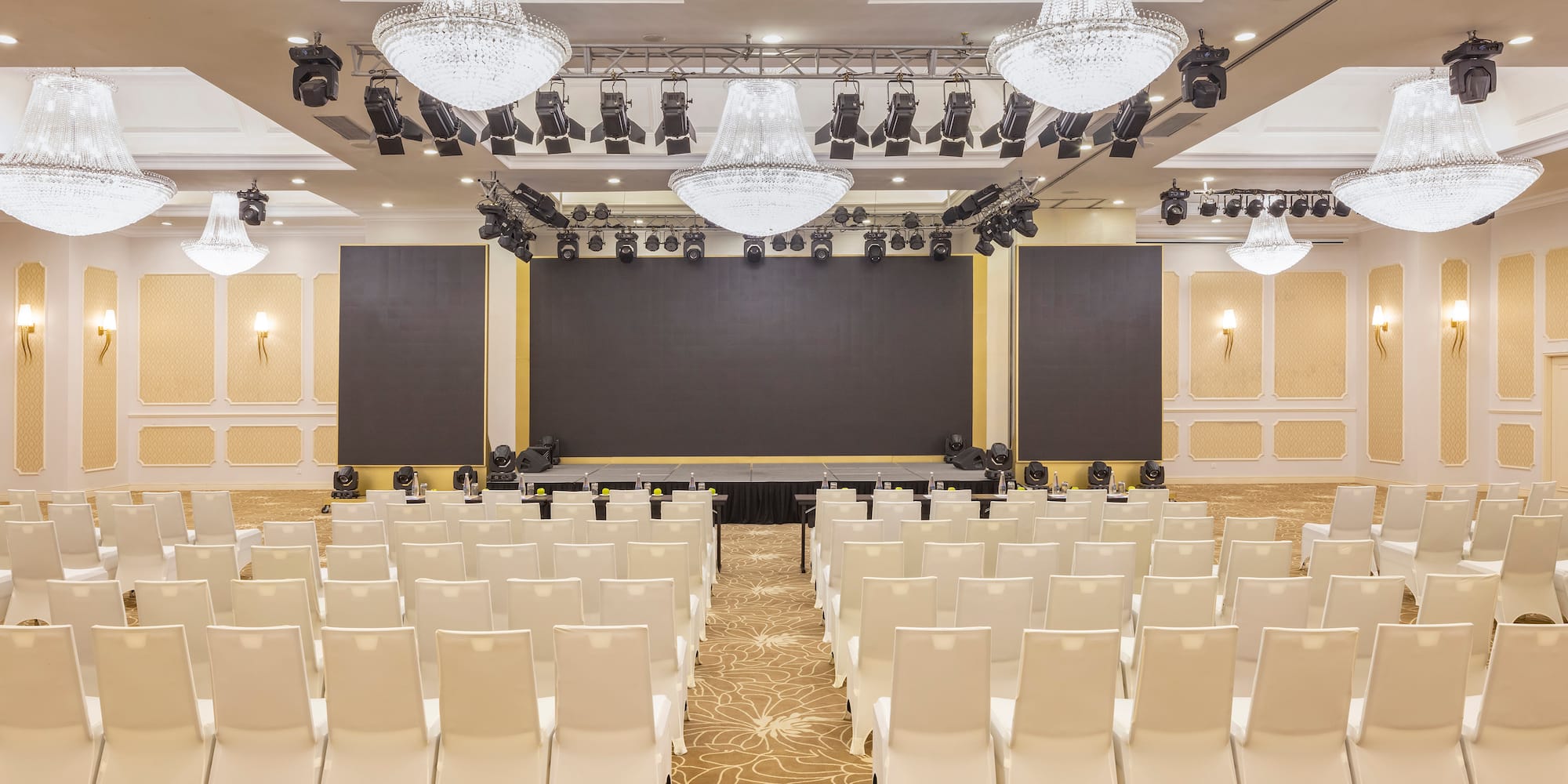 a room with white chairs and a stage