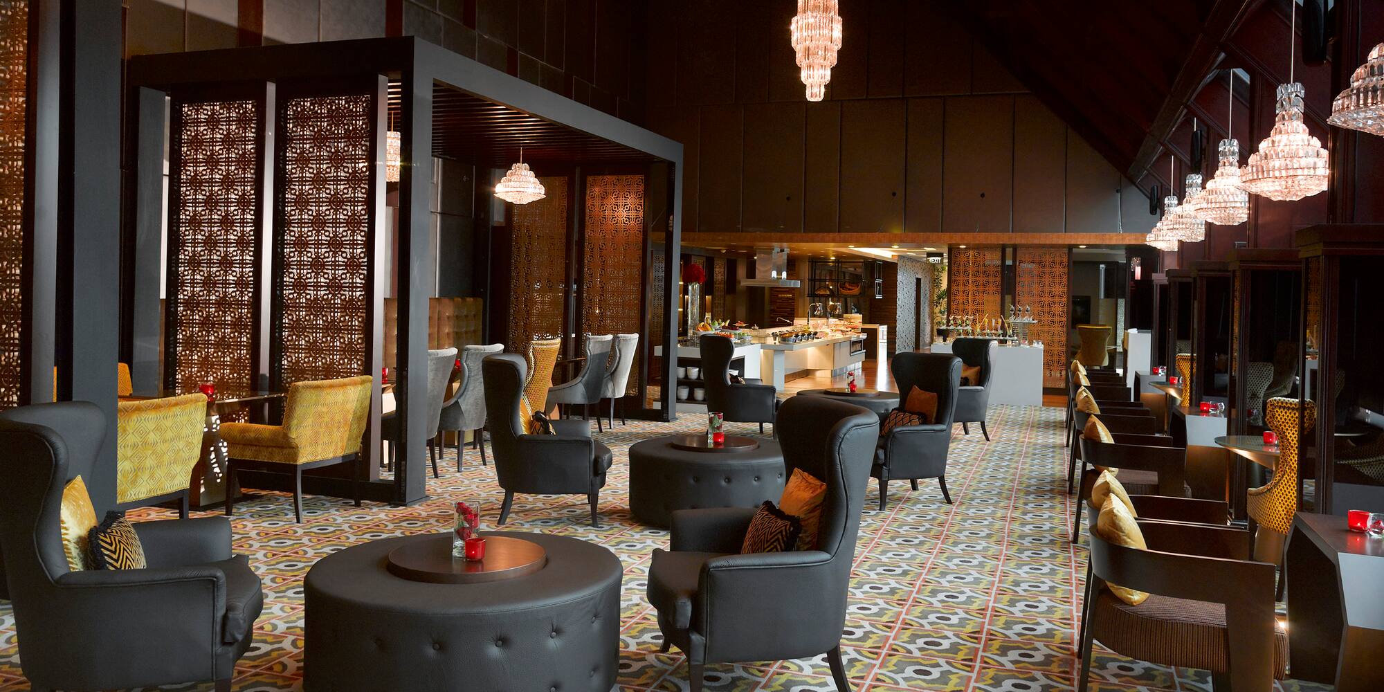 Elegant lounge with black chairs, patterned floor, crystal chandeliers, buffet.