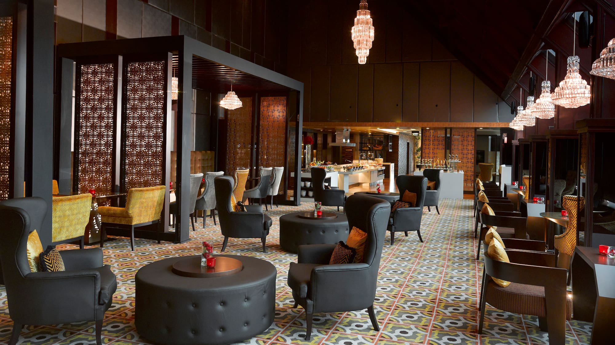Elegant lounge with black chairs, patterned floor, crystal chandeliers, buffet.
