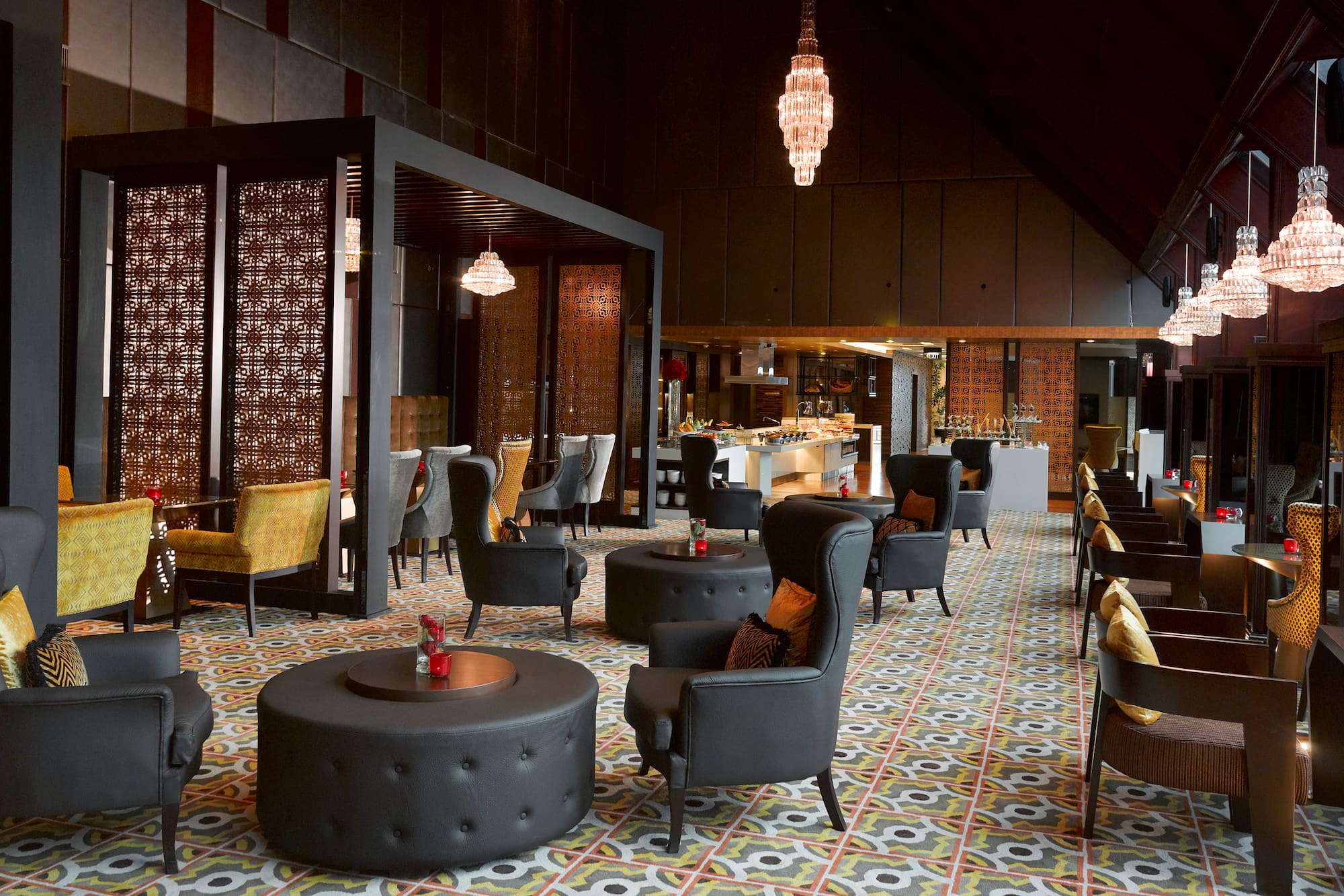 Elegant lounge with black chairs, patterned floor, crystal chandeliers, buffet.