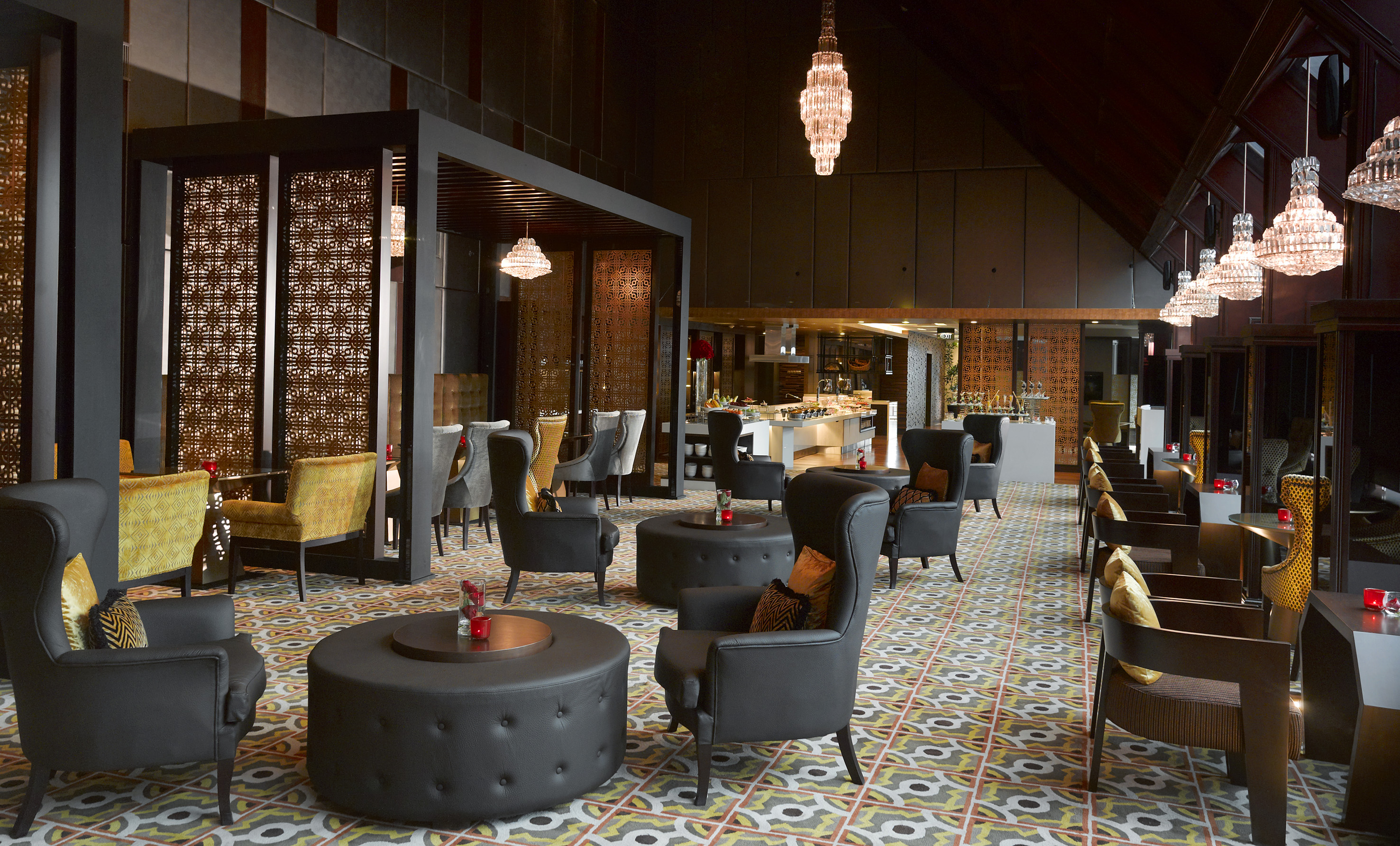 Elegant lounge with black chairs, patterned floor, crystal chandeliers, buffet.
