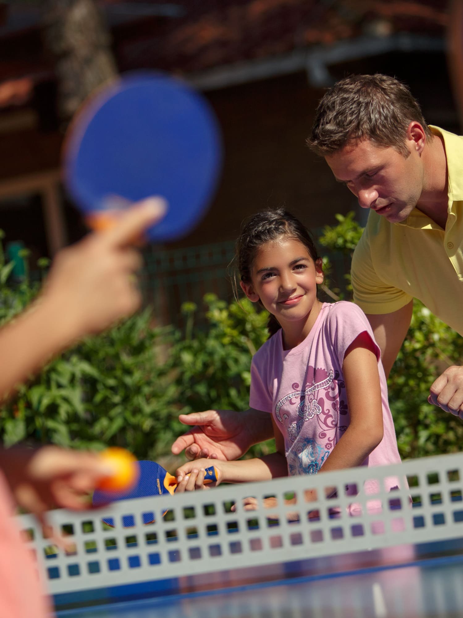 a man and a girl playing ping pong