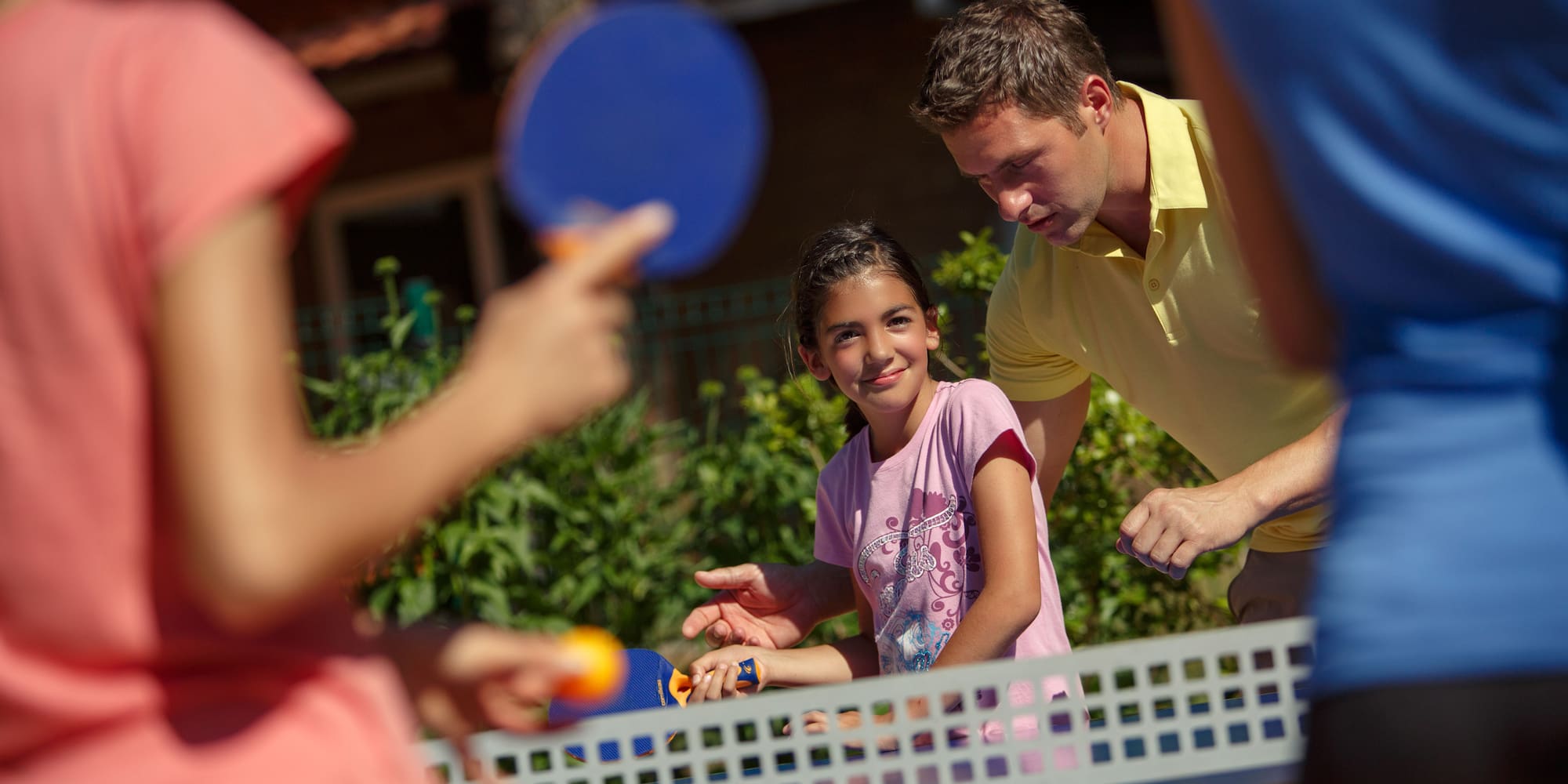 a man and a girl playing ping pong