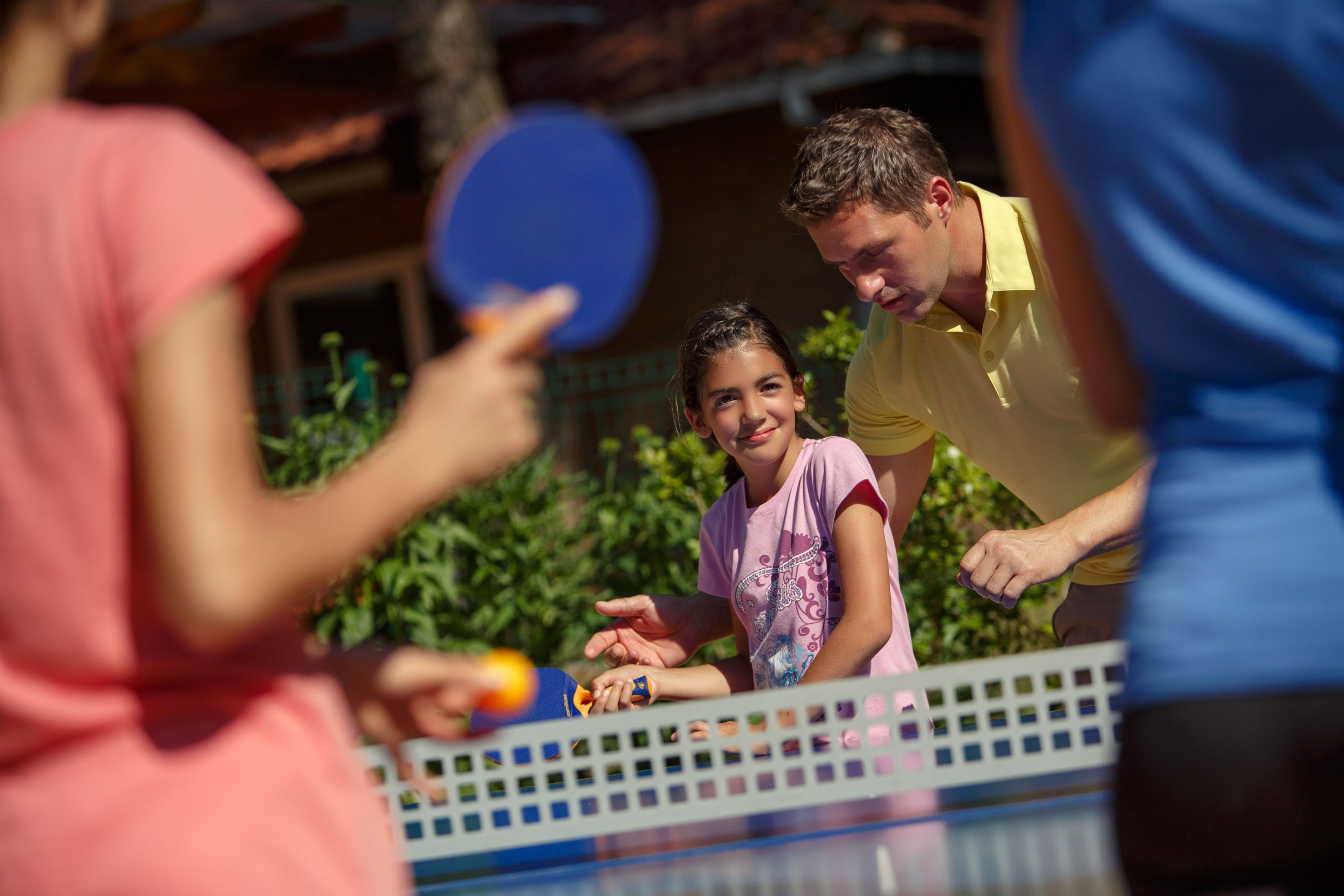 a man and a girl playing ping pong