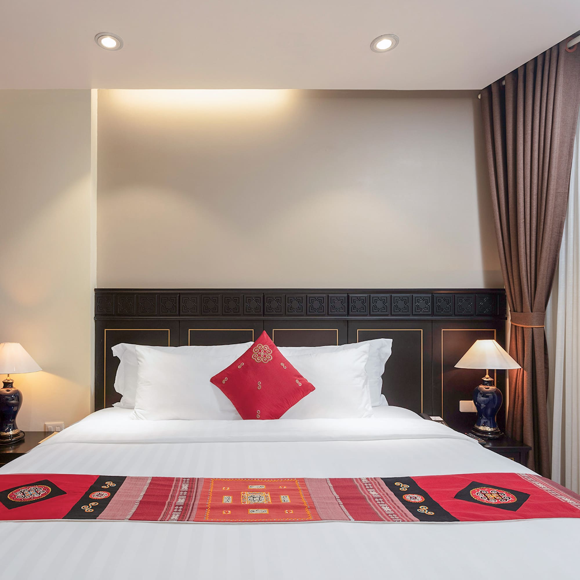 a bed with pillows and lamps in a room