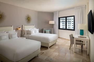 a room with two beds and a desk