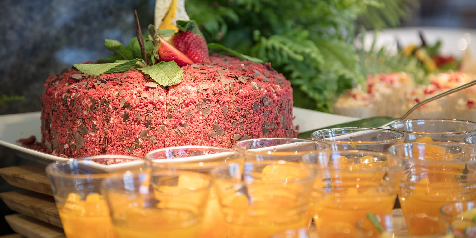 a table with a cake and glasses of orange liquid