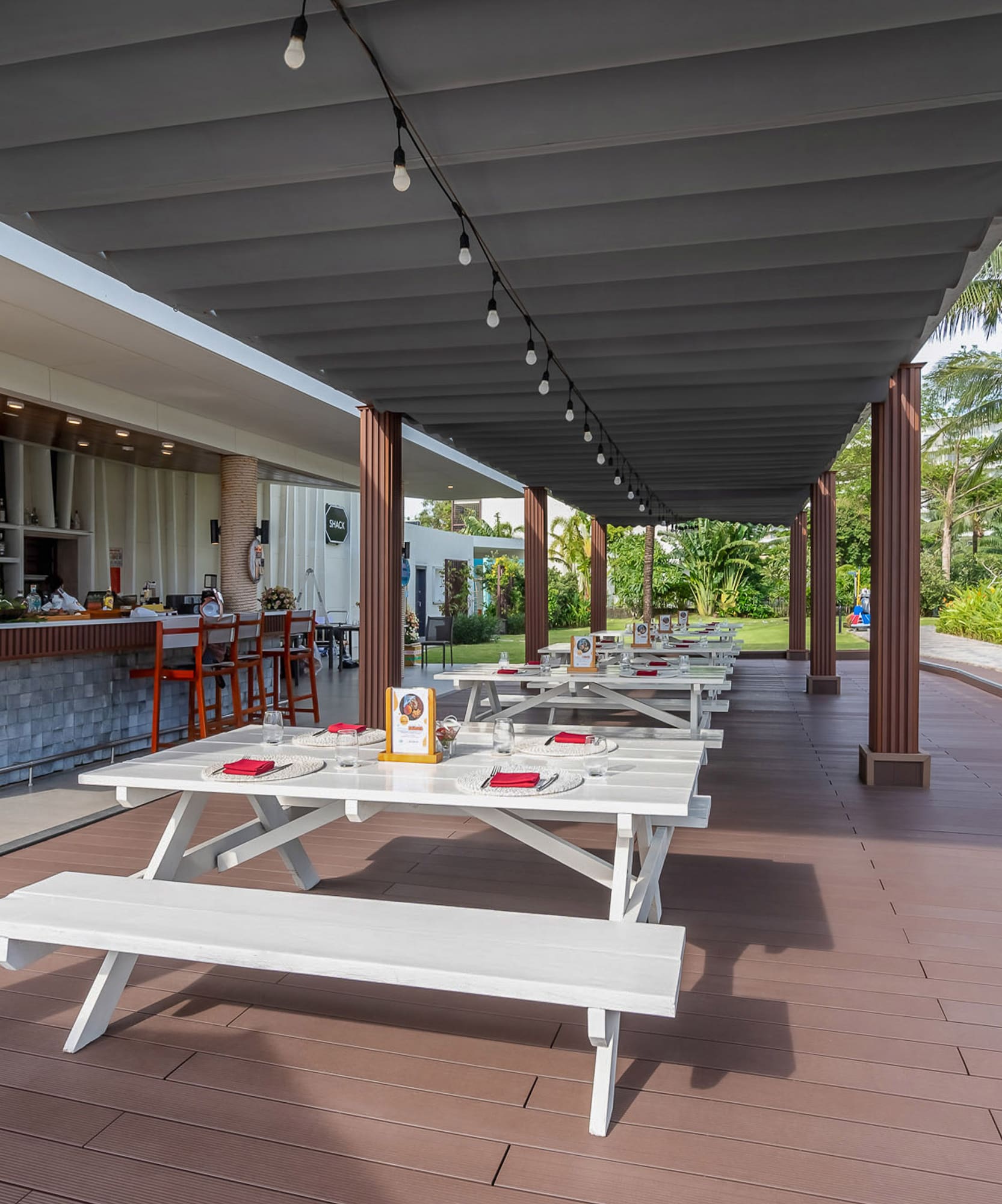 a covered patio with tables and chairs